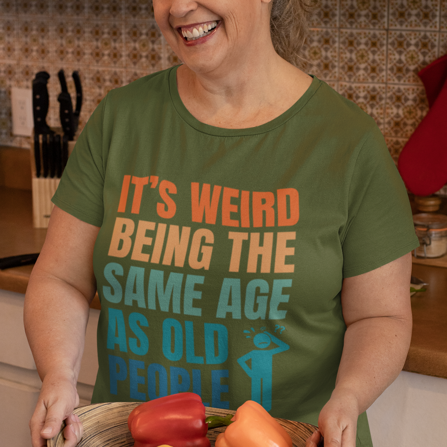 Military green tee featuring bold, multi-color lettering and with a pictogram of a person scratching their head in confusion