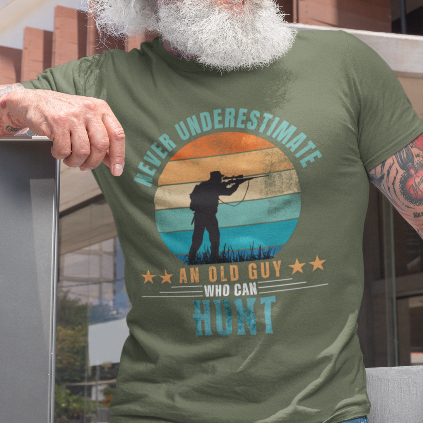 Military green tee featuring silhouette of a hunter with a rifle cast against a stylish distressed striped sunset