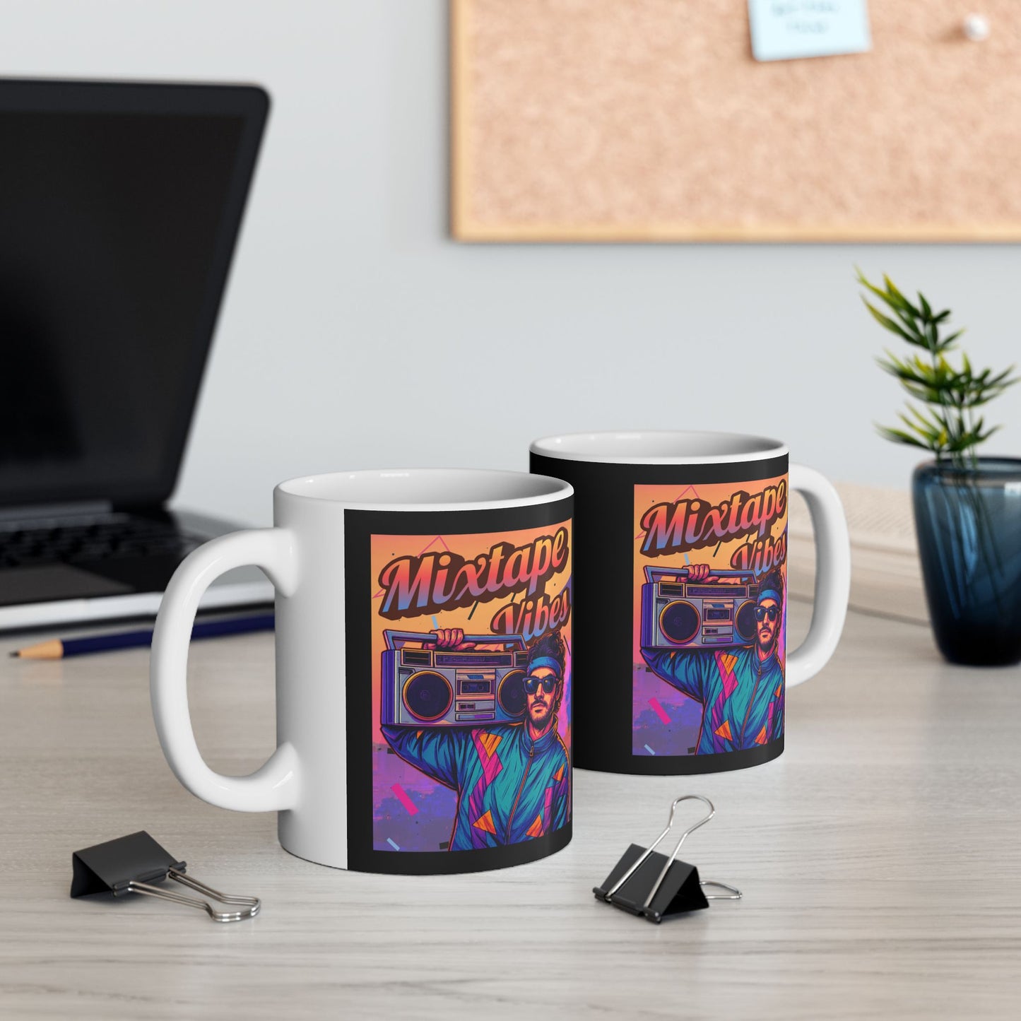 Two mugs with 'Mixtape Artist' design on a desk with office items.