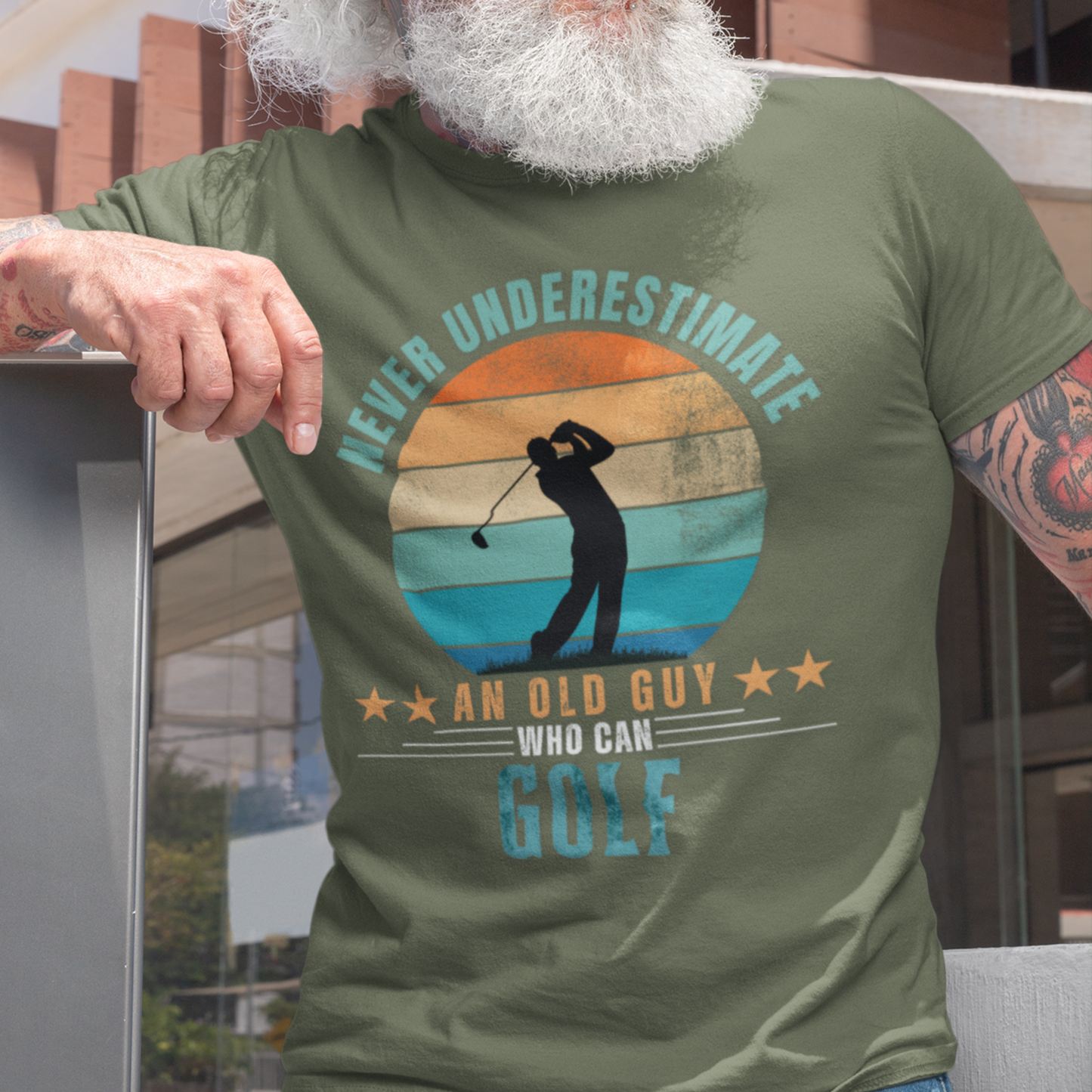 Military green tee featuring silhouette of a guy swinging a golf club against a distressed striped sunset