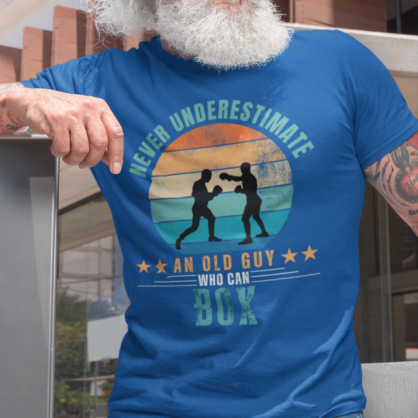 Royal blue tee featuring silhouette two guys boxing against a distressed striped sunset