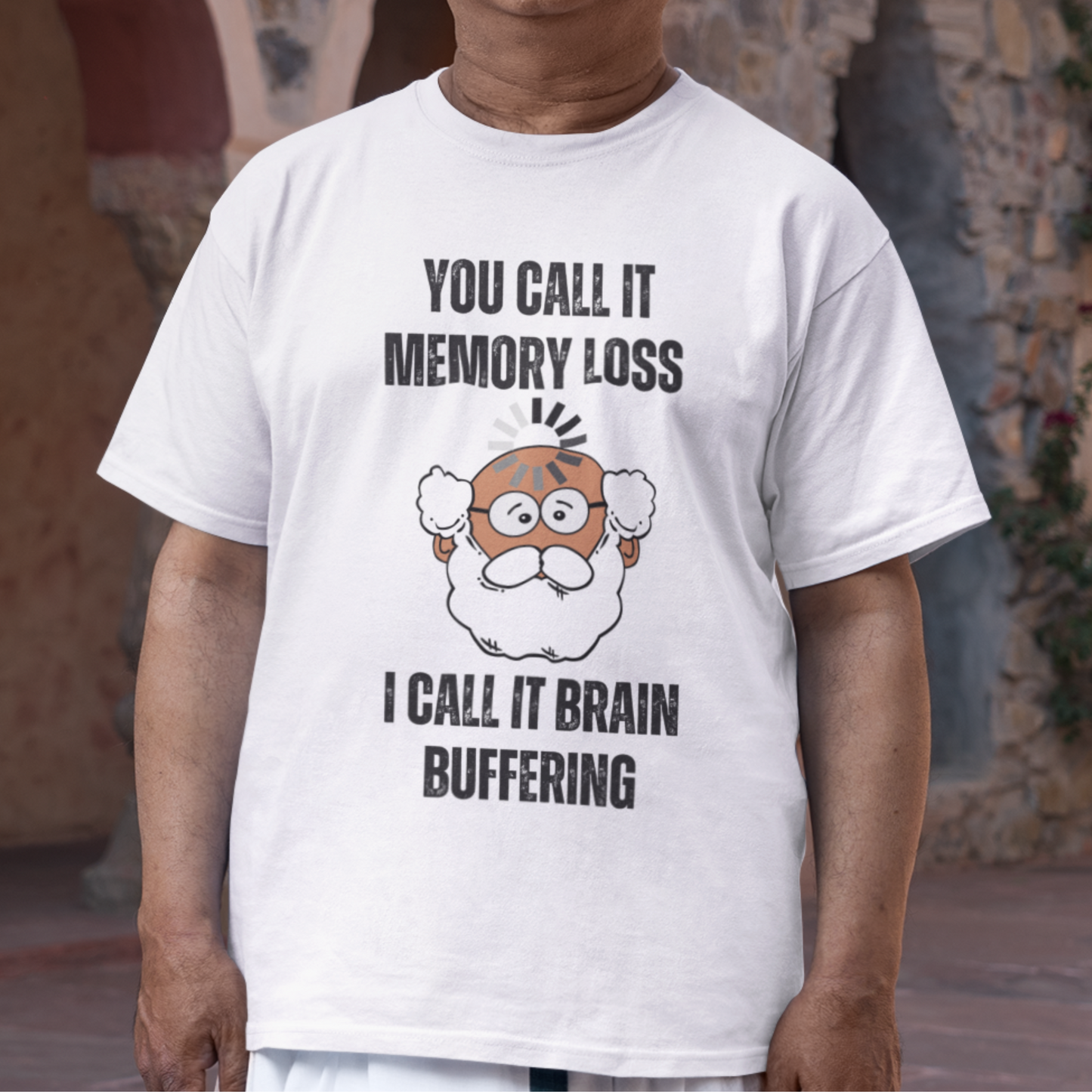 White t-shirt featuring the phrase 'Brain Buffering' with a loading icon graphic and a bald, bearded medium-toned senior.