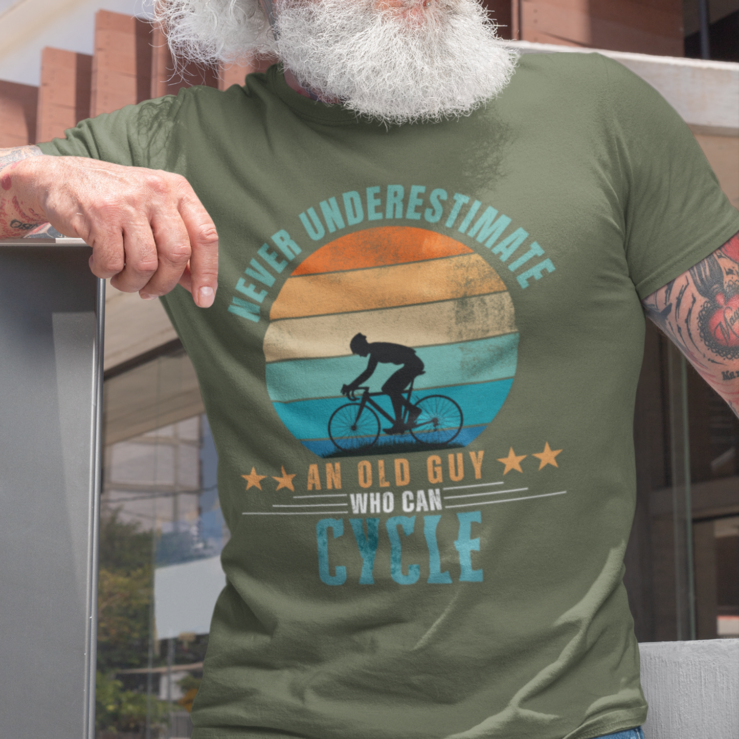 Military green tee featuring silhouette of a guy on a bicycle against a distressed striped sunset