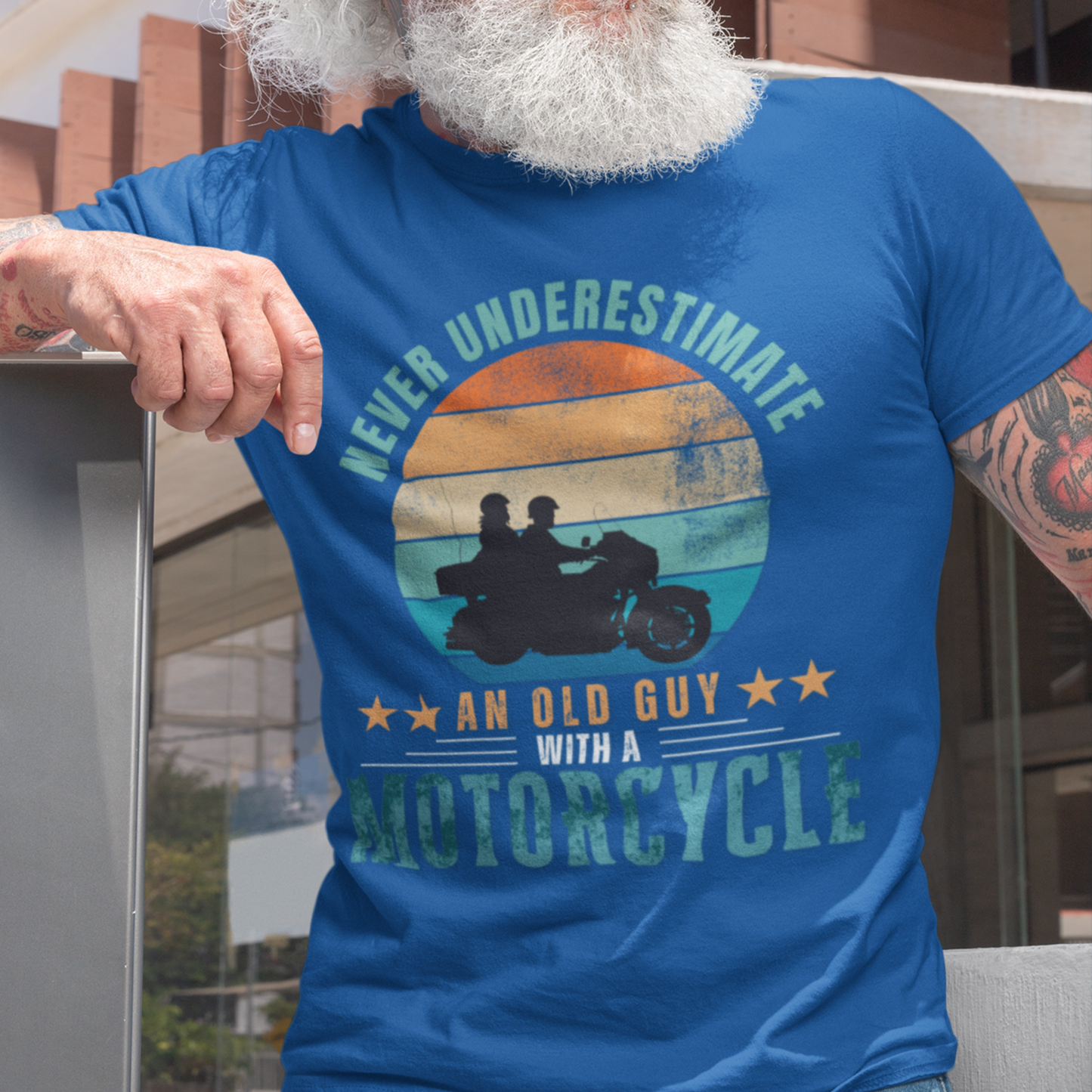 Royal blue tee featuring silhouette of a guy on a cruiser with his lady against a distressed striped sunset