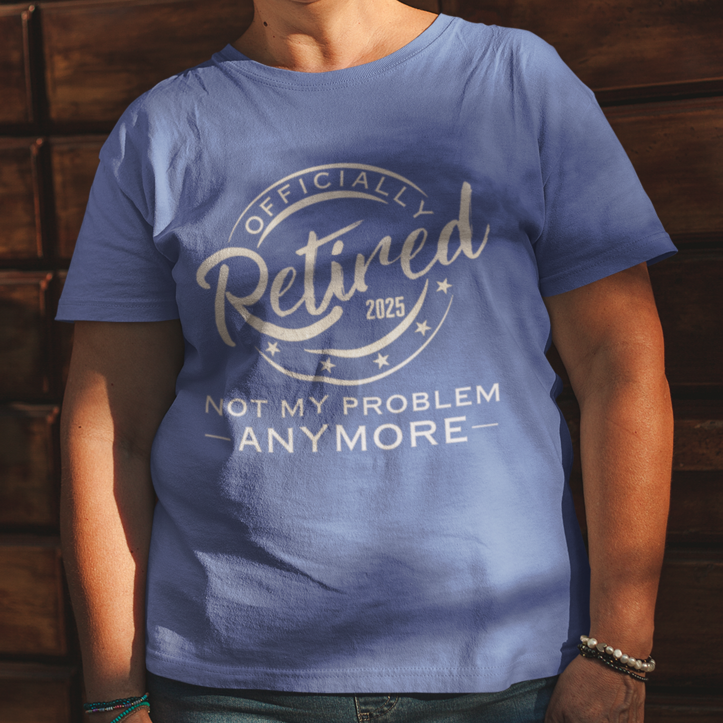 Royal blue tee featuring a replica of an official stamp embossing that reads "Officially Retired 2025 Not My Problem Anymore"