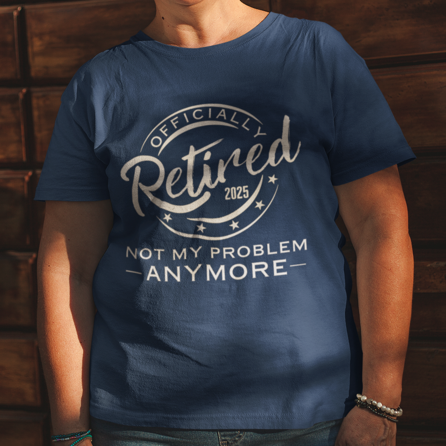 Navy blue tee featuring a replica of an official stamp embossing that reads "Officially Retired 2025 Not My Problem Anymore"