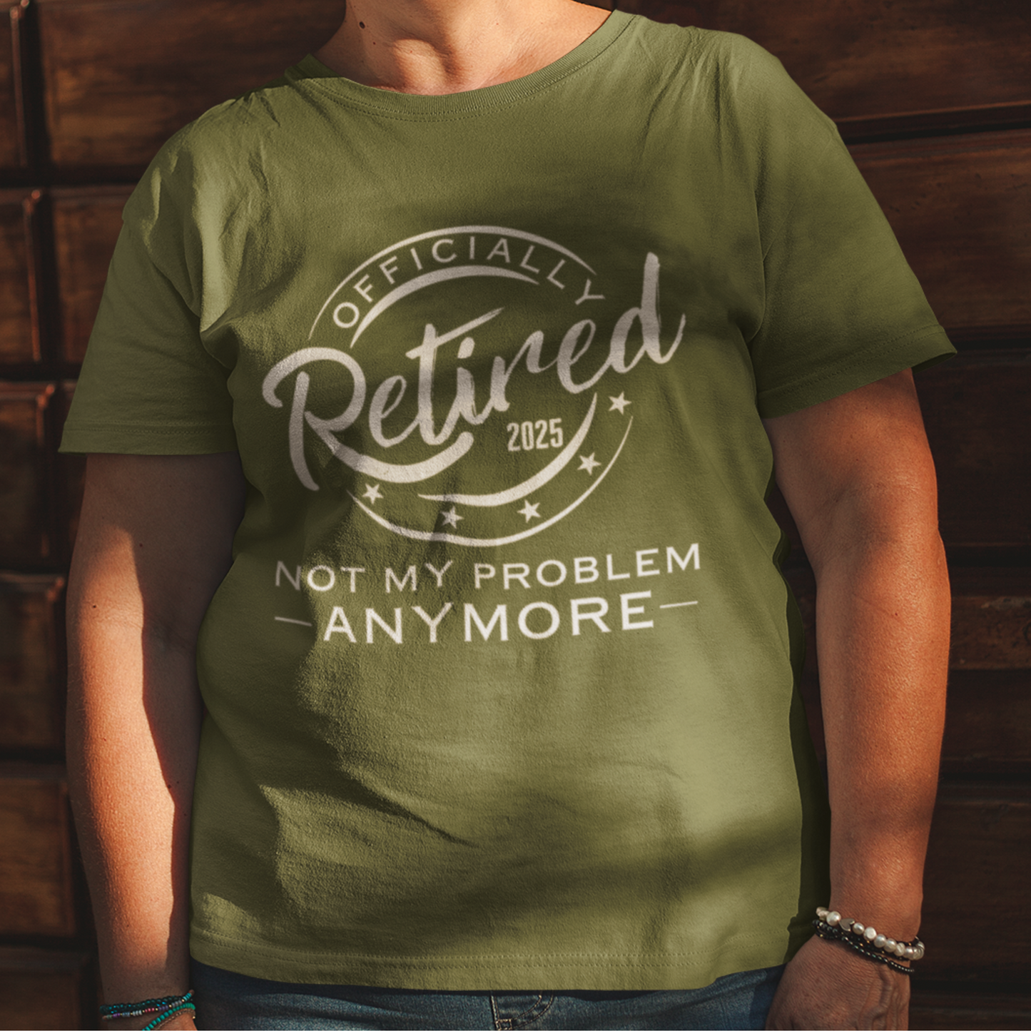 Military green tee featuring a replica of an official stamp embossing that reads "Officially Retired 2025 Not My Problem Anymore"