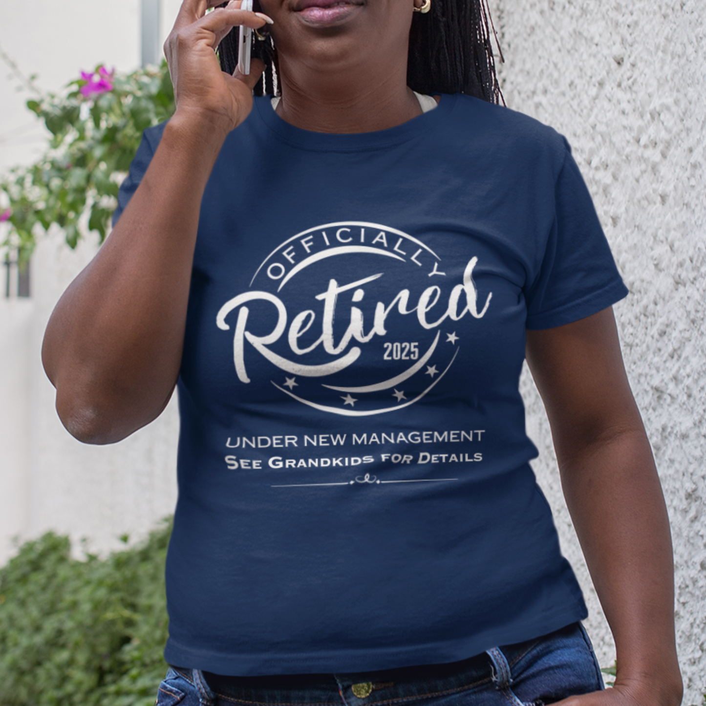 Navy blue tee featuring a replica of an official stamp embossing that reads "Officially Retired 2025 See Grandkids" on a woman.