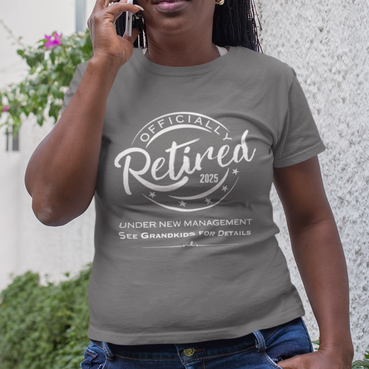 Heather gray tee featuring a replica of an official stamp embossing that reads "Officially Retired 2025 See Grandkids" on a woman.