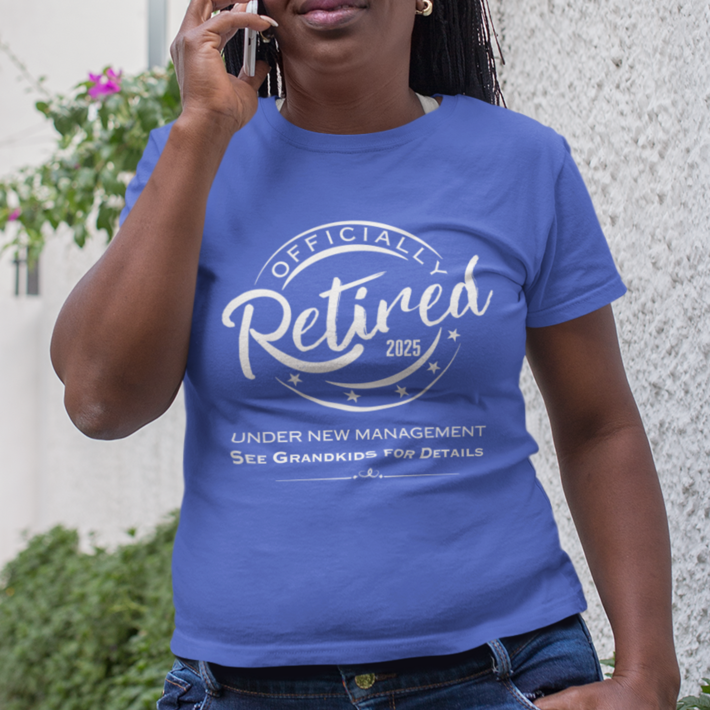 Royal blue tee featuring a replica of an official stamp embossing that reads "Officially Retired 2025 See Grandkids" on a woman.