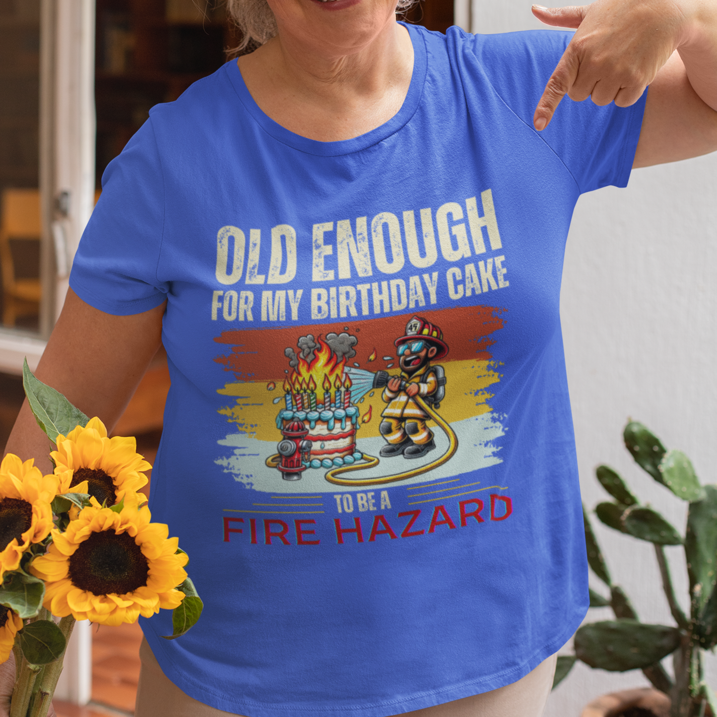 Royal blue tee featuring a cartoon fireman putting out the flames from the candles on a birthday cake.