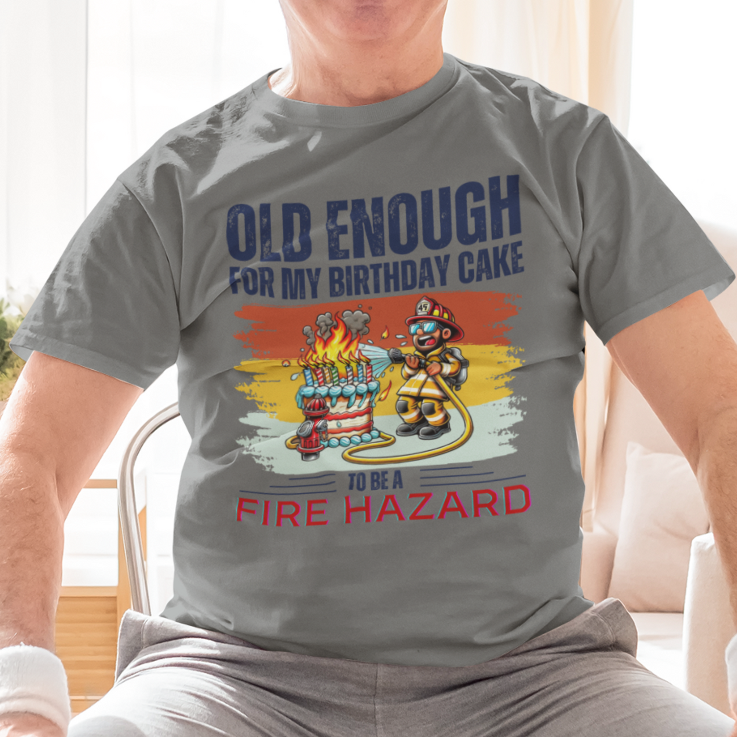 Heather gray tee featuring a cartoon fireman putting out the flames from the candles on a birthday cake.