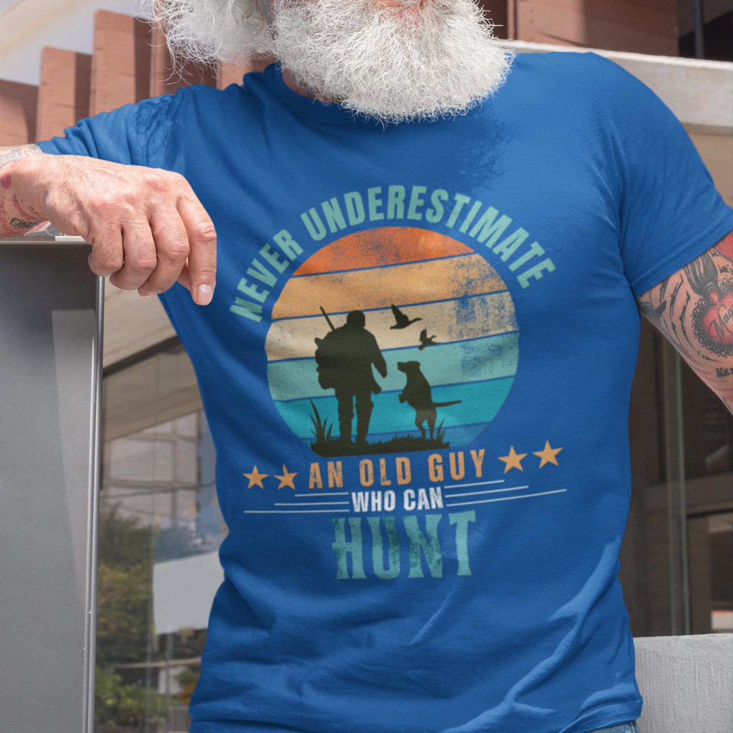 Royal blue tee featuring silhouette of a hunter with a shotgun and his trusty dog cast against a stylish distressed striped sunset