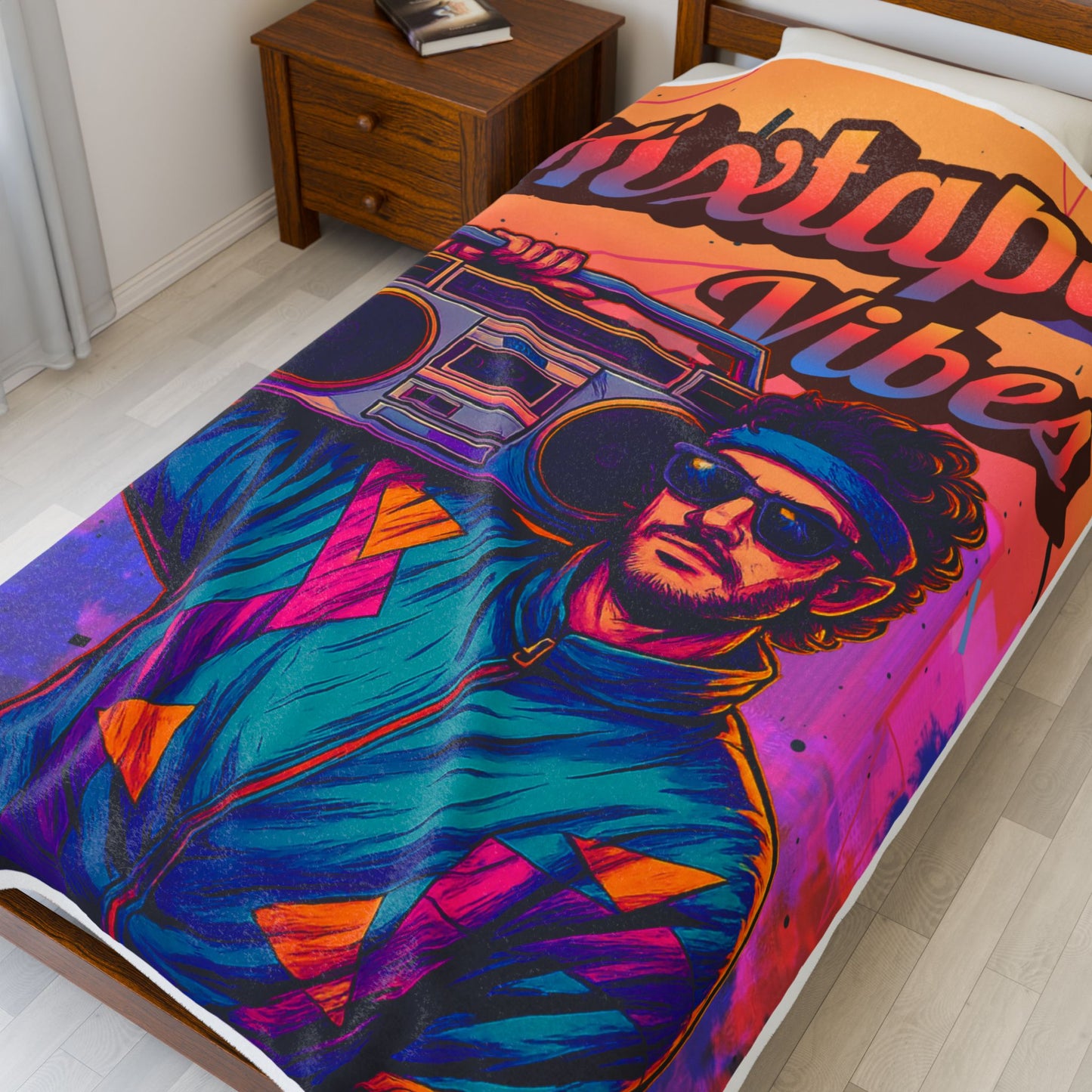 60X80 colorful blanket with a graphic design of a person wearing sunglasses and a jacket, with 'Mixtape Vibes' text, on a bed in a room.
