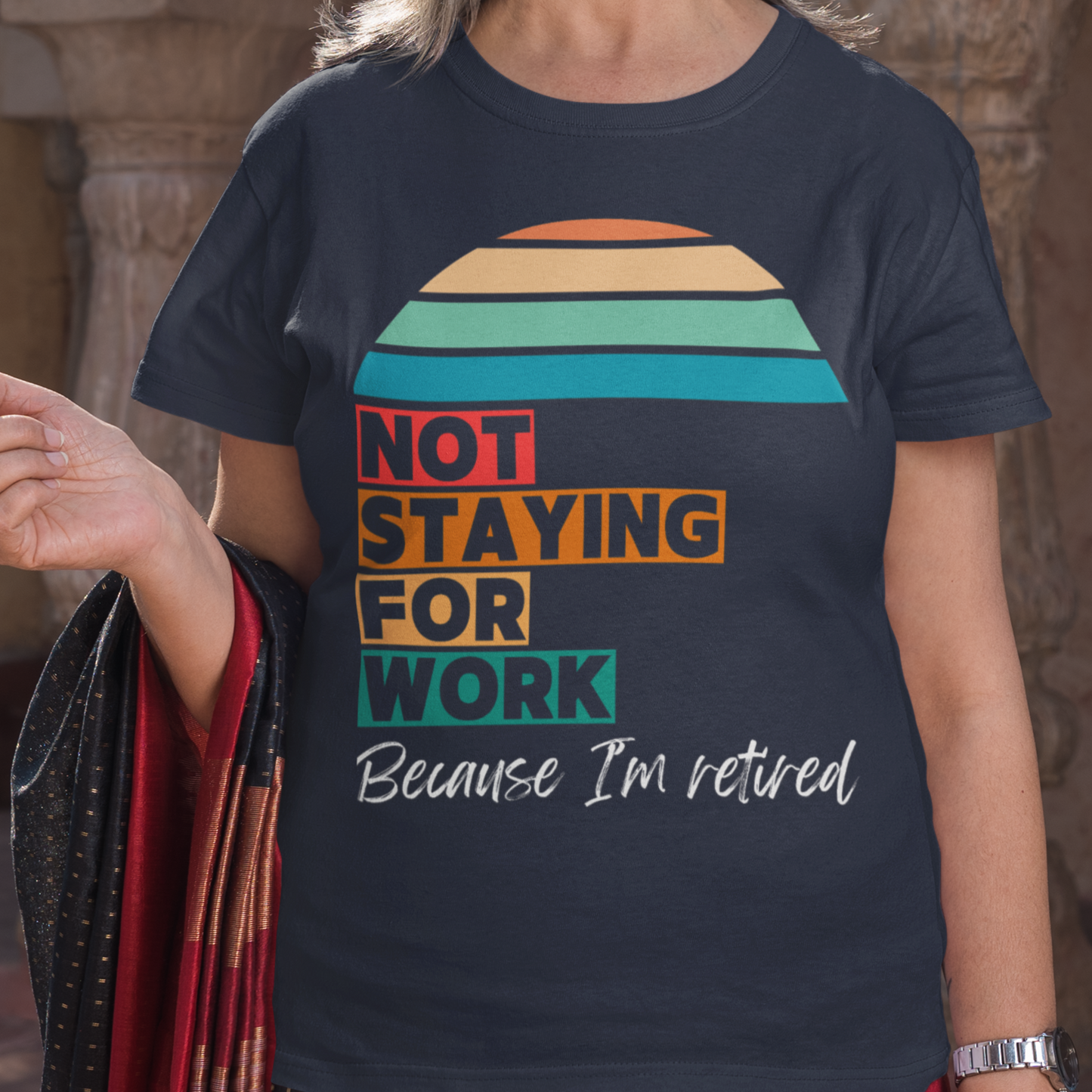 Navy blue tee in multi-color block lettering and rainbow sun reads Not Staying for Work I'm Retired