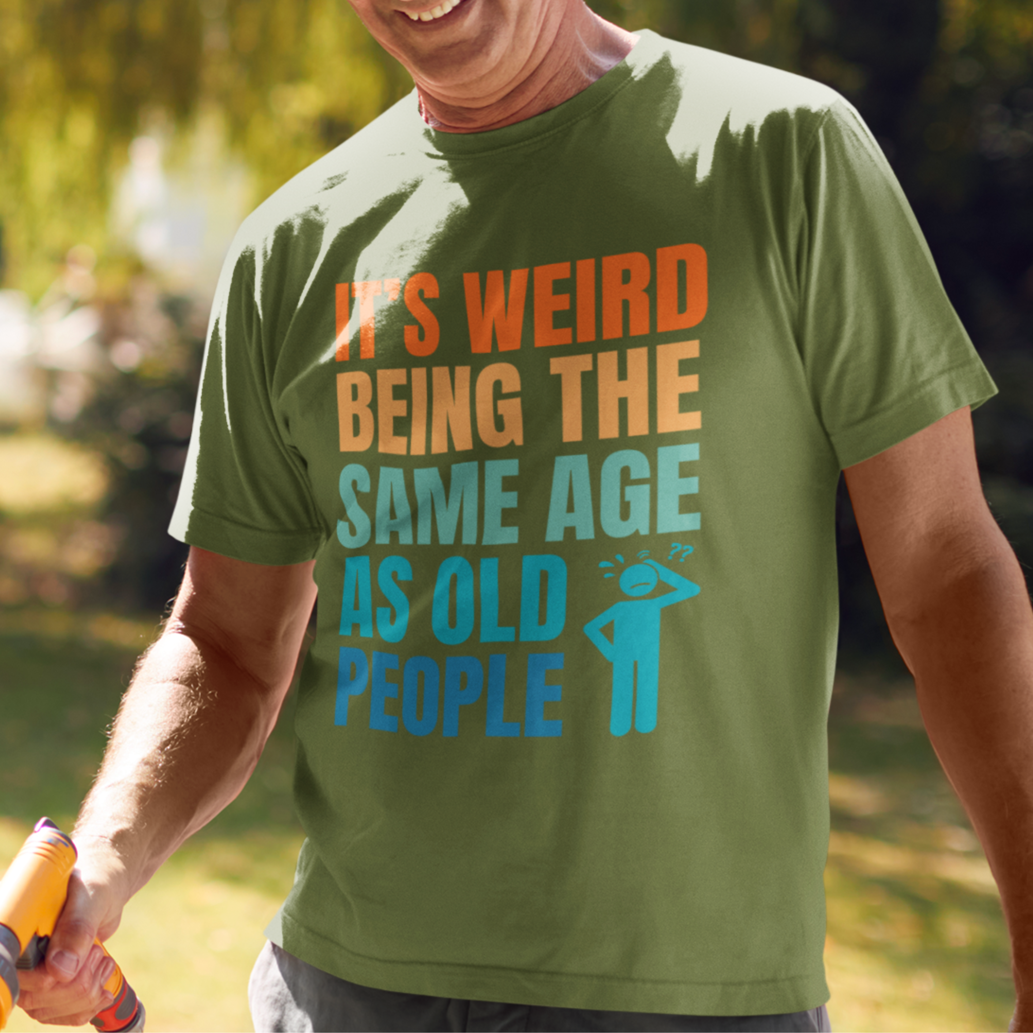 Military green tee featuring bold, multi-color lettering and with a pictogram of a person scratching their head in confusion