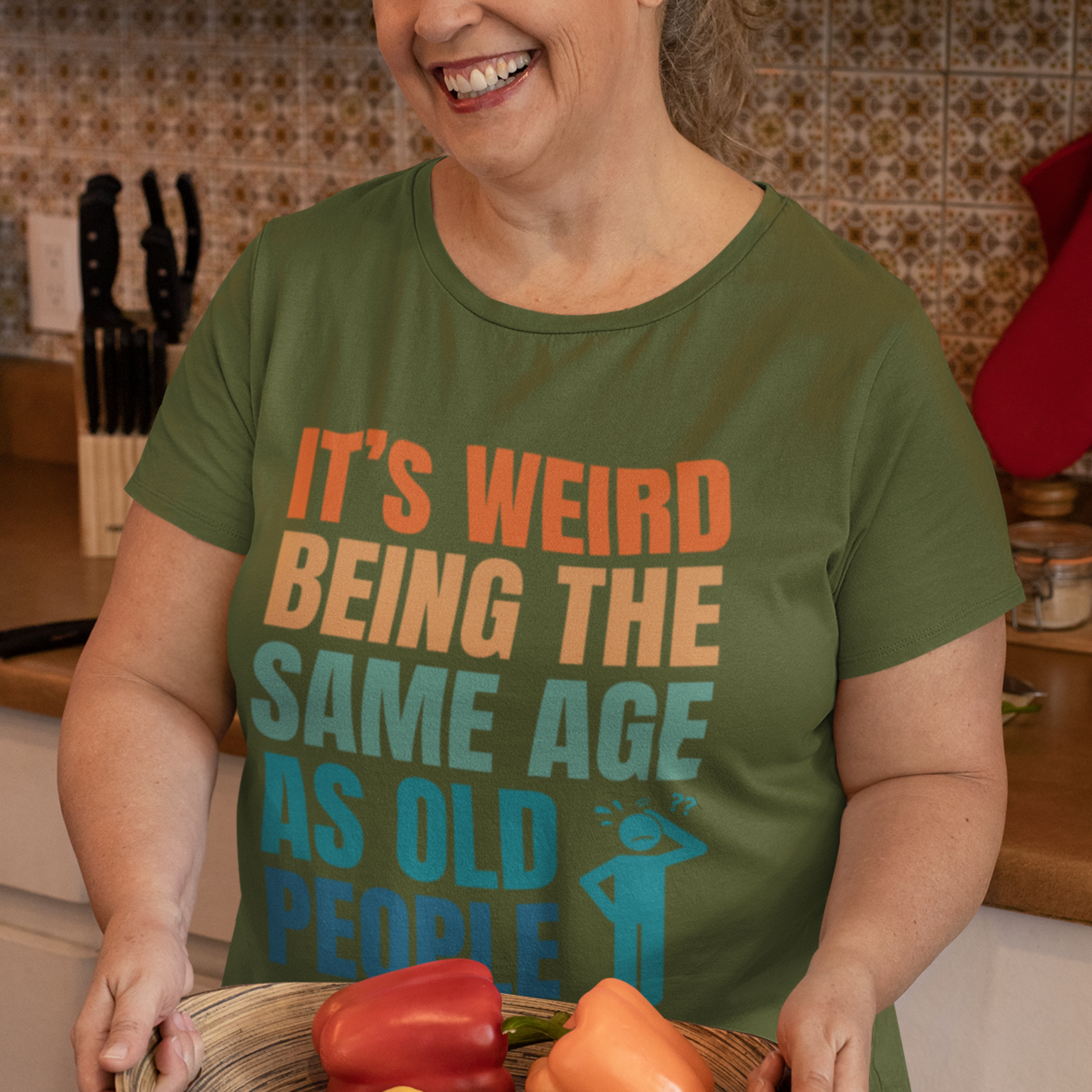 Military green tee featuring bold, multi-color lettering and with a pictogram of a person scratching their head in confusion