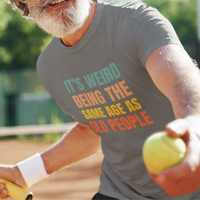 Gray tee featuring bold, rainbow-colored lettering reads It’s Weird Being the Same Age as Old People 