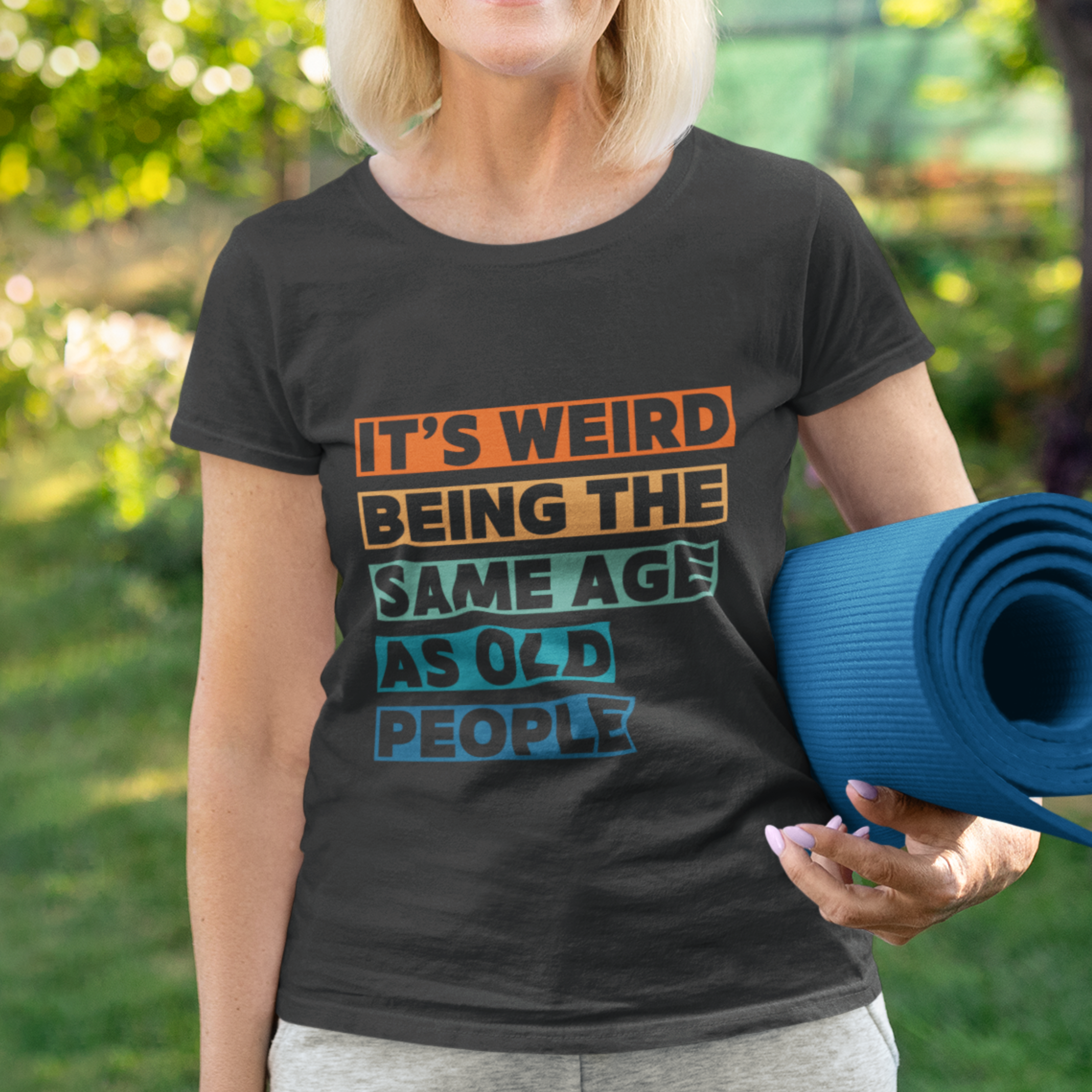Black tee featuring bold, multi-color block lettering reads It’s Weird Being the Same Age as Old People 