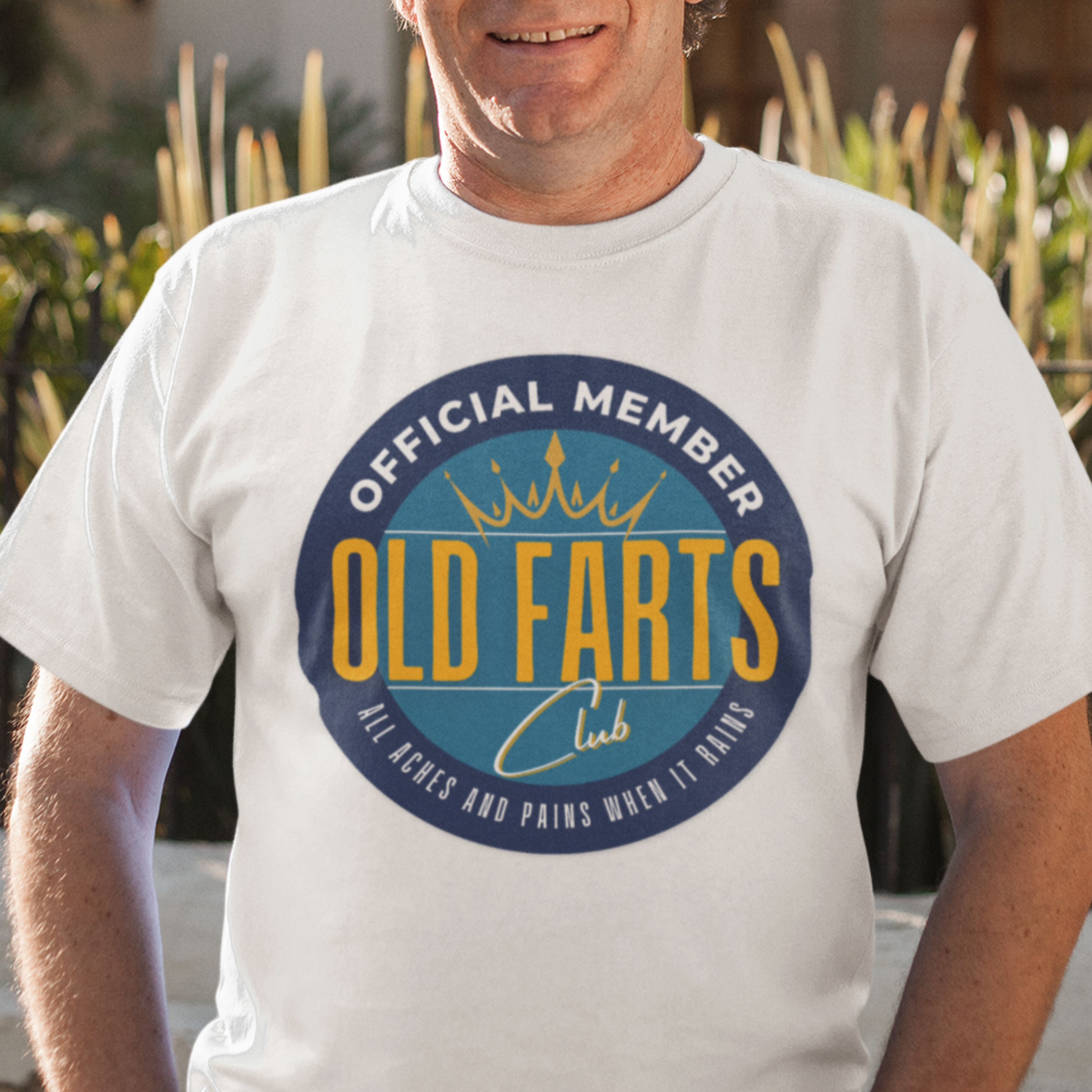 White tee featuring a yellow and blue emblem that reads Official Member Old Farts Club All Aches and Pains When it Rains