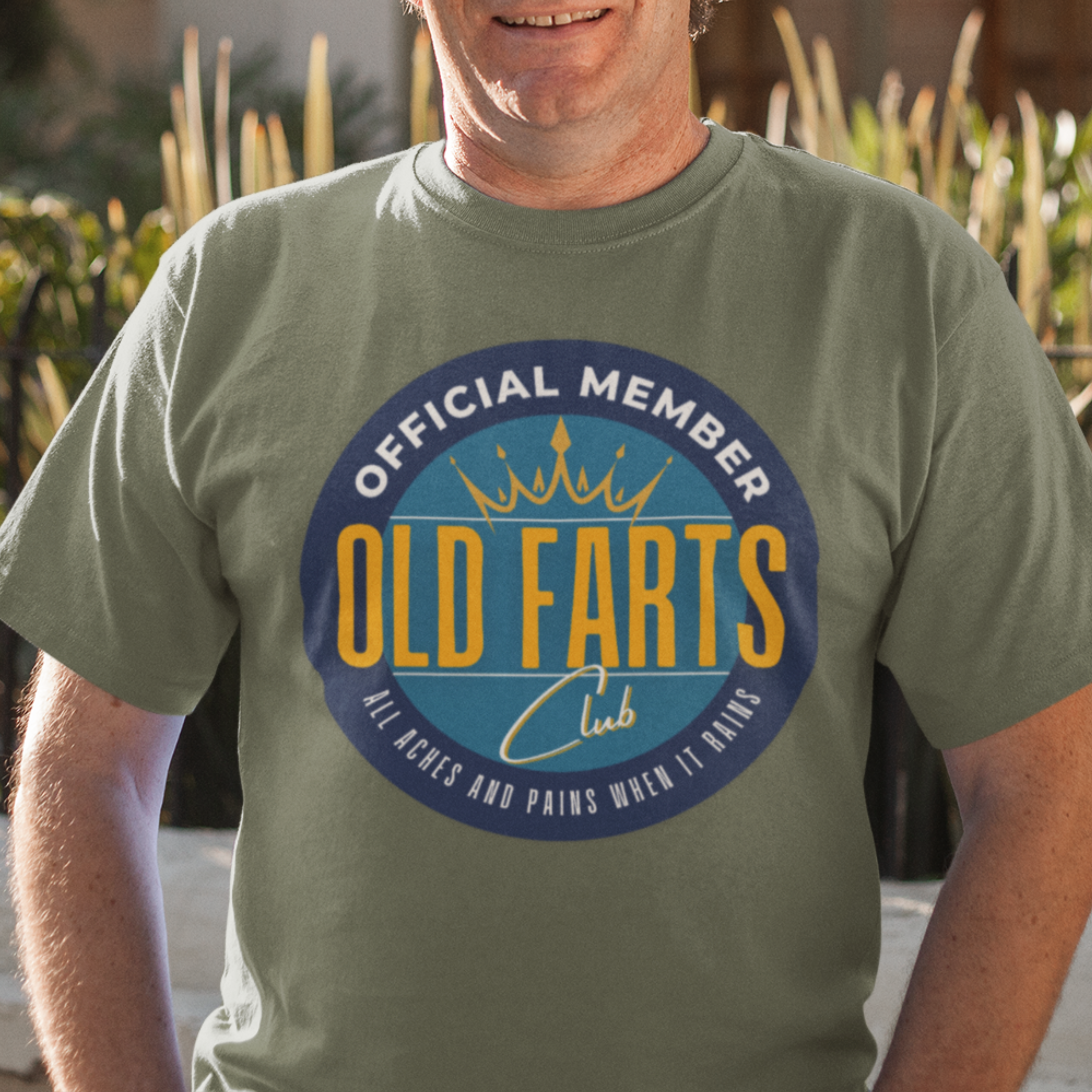 Military green tee featuring a yellow and blue emblem that reads Official Member Old Farts Club All Aches and Pains When it Rains