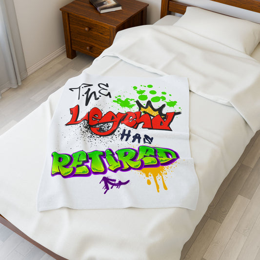 30X40 White blanket with colorful text design that reads "The Legend Has Retired" on a bed in a bedroom.