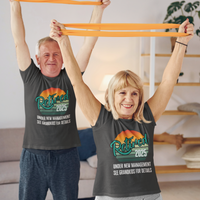 A couple in black t-shirts featuring a rainbow striped sun that reads Retired 2025 Under New Management See Grandkids for Details.