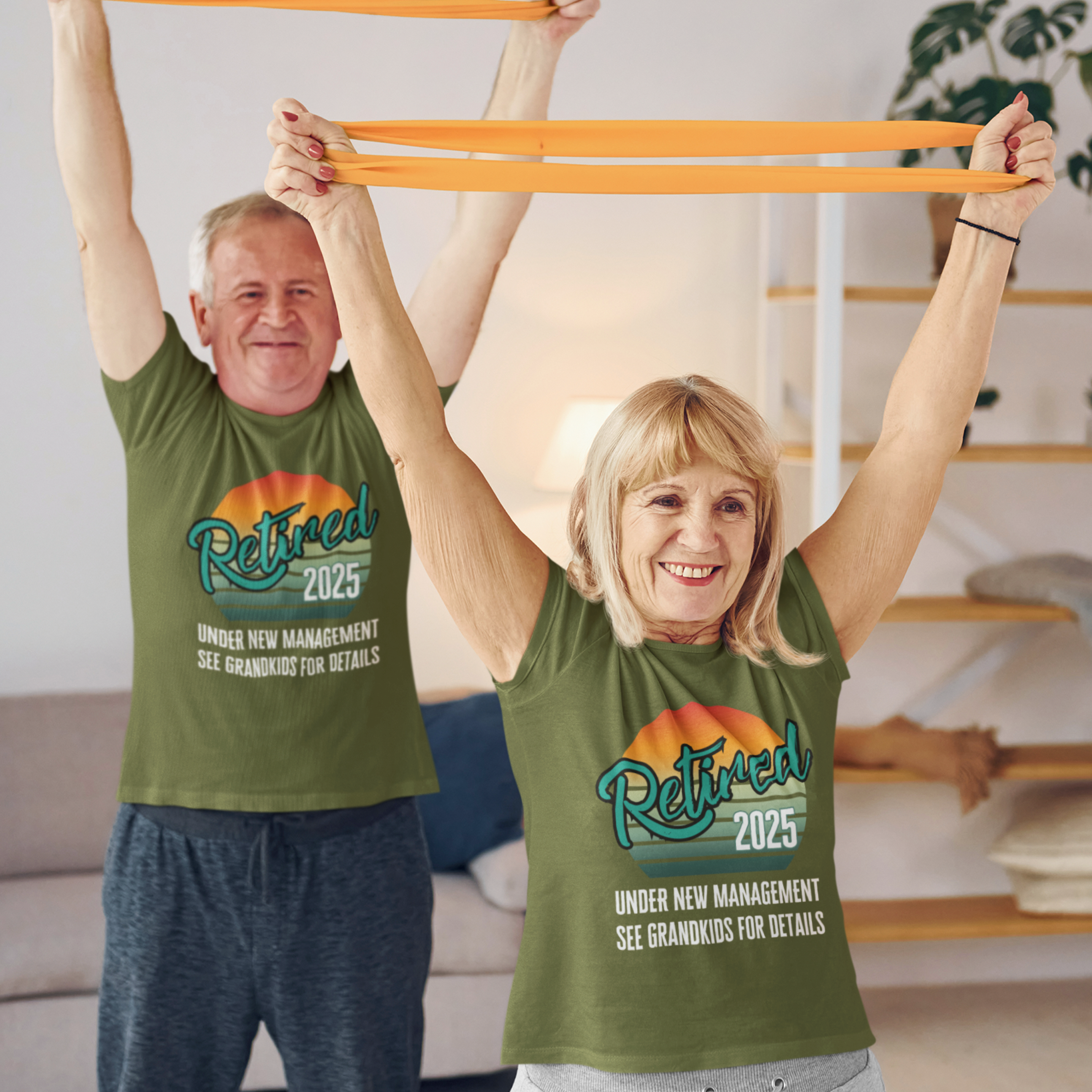 A couple in military green t-shirts featuring a rainbow striped sun that reads Retired 2025 Under New Management See Grandkids for Details.