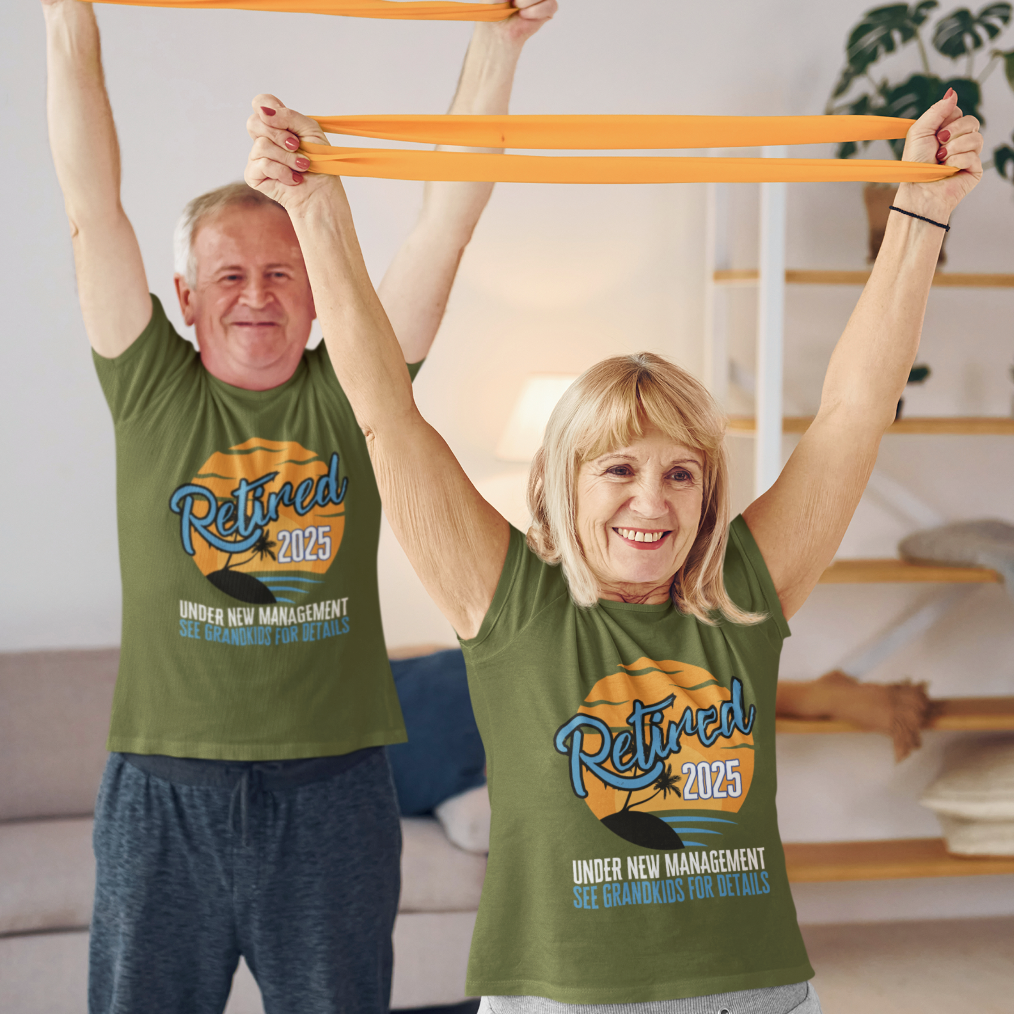 A couple in military green t-shirts featuring a sunset beach scene that reads Retired 2025 Under New Management See Grandkids for Details.