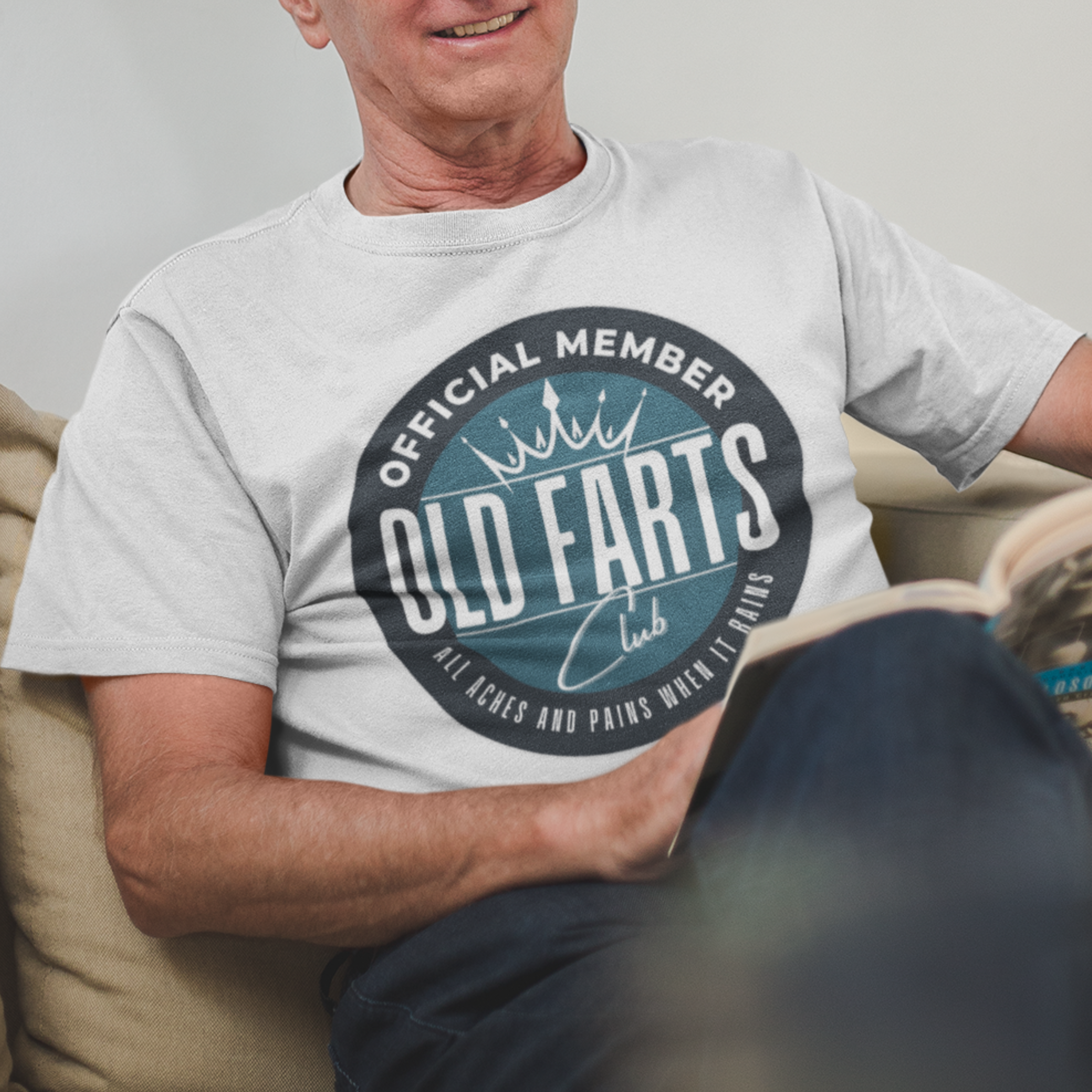 White tee featuring a blue-green insignia that reads Official Member Old Farts Club All Aches and Pains When it Rains