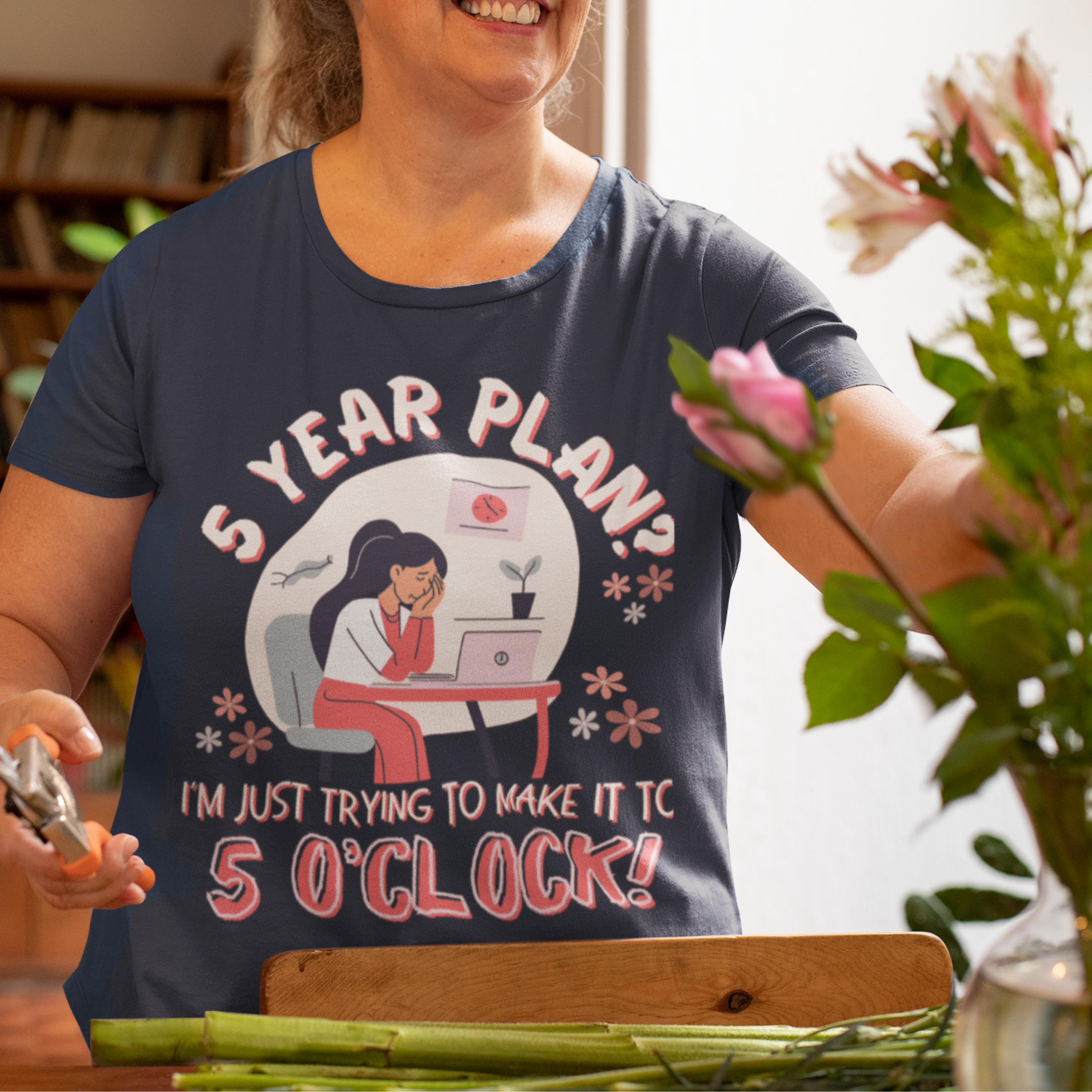 Navy blue t-shirt featuring an overwhelmed worker with her head down in her laptop that reads, 5 Year Plan? I'm Just Trying to Make it to 5 O'clock.