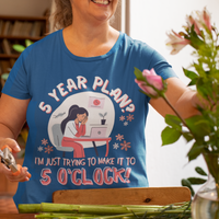 Royal blue t-shirt featuring an overwhelmed worker with her head down in her laptop that reads, 5 Year Plan? I'm Just Trying to Make it to 5 O'clock.
