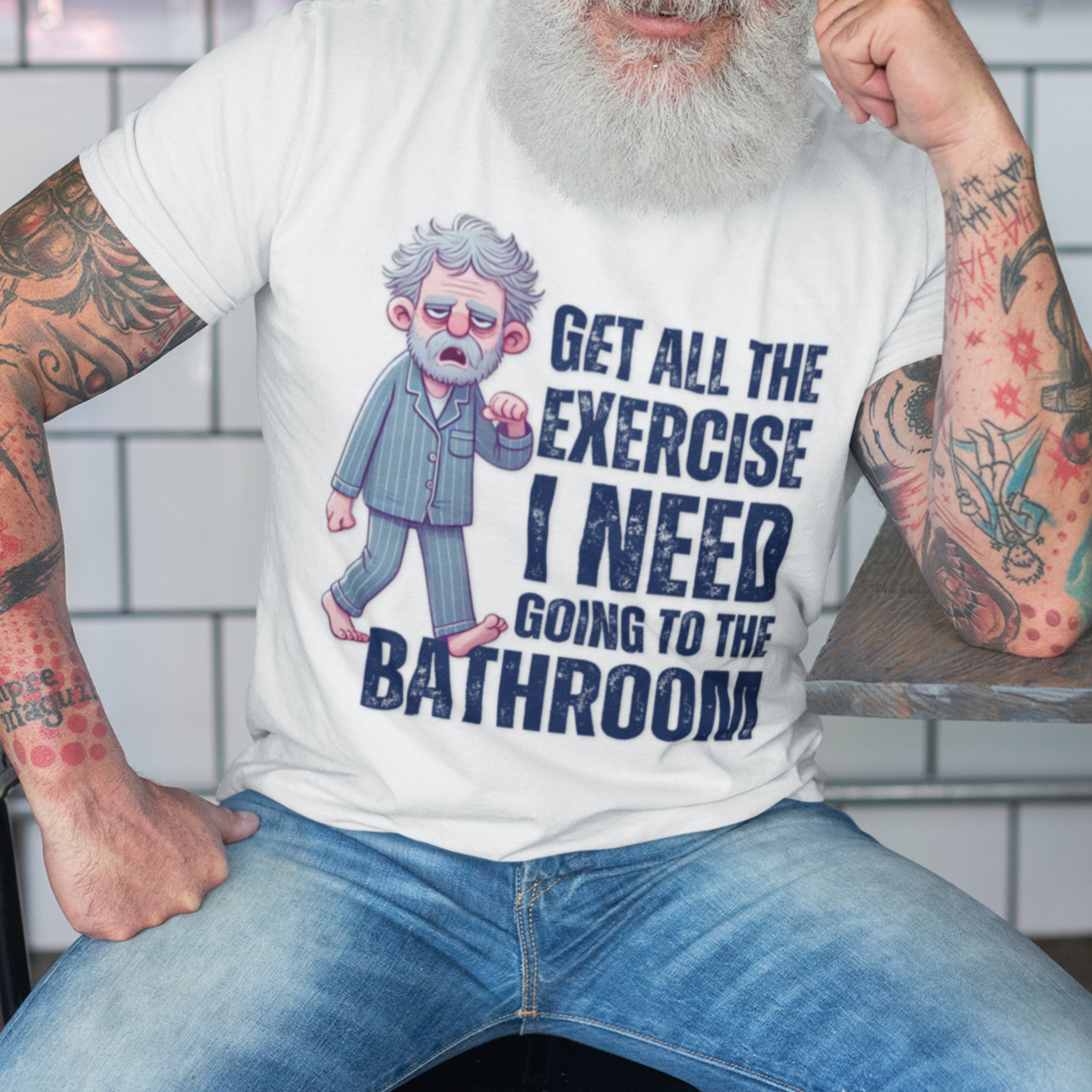 White t-shirting featur a gray-haired man in pajamas with distressed bold lettering, "Get All The Exercise I Need Going to the Bathroom"