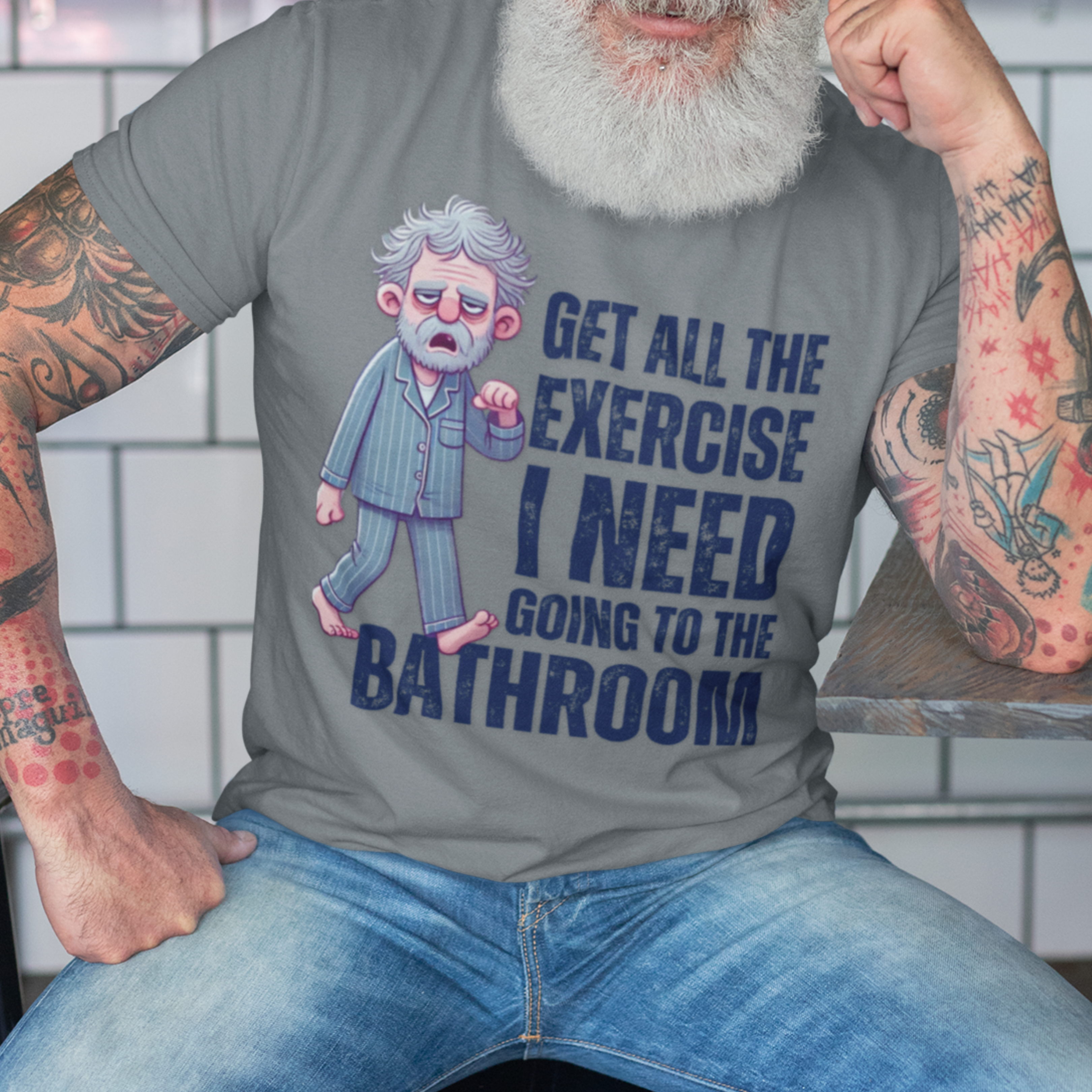 Heather gray t-shirt featuring a gray-haired man in pajamas with distressed bold lettering, "Get All The Exercise I Need Going to the Bathroom"