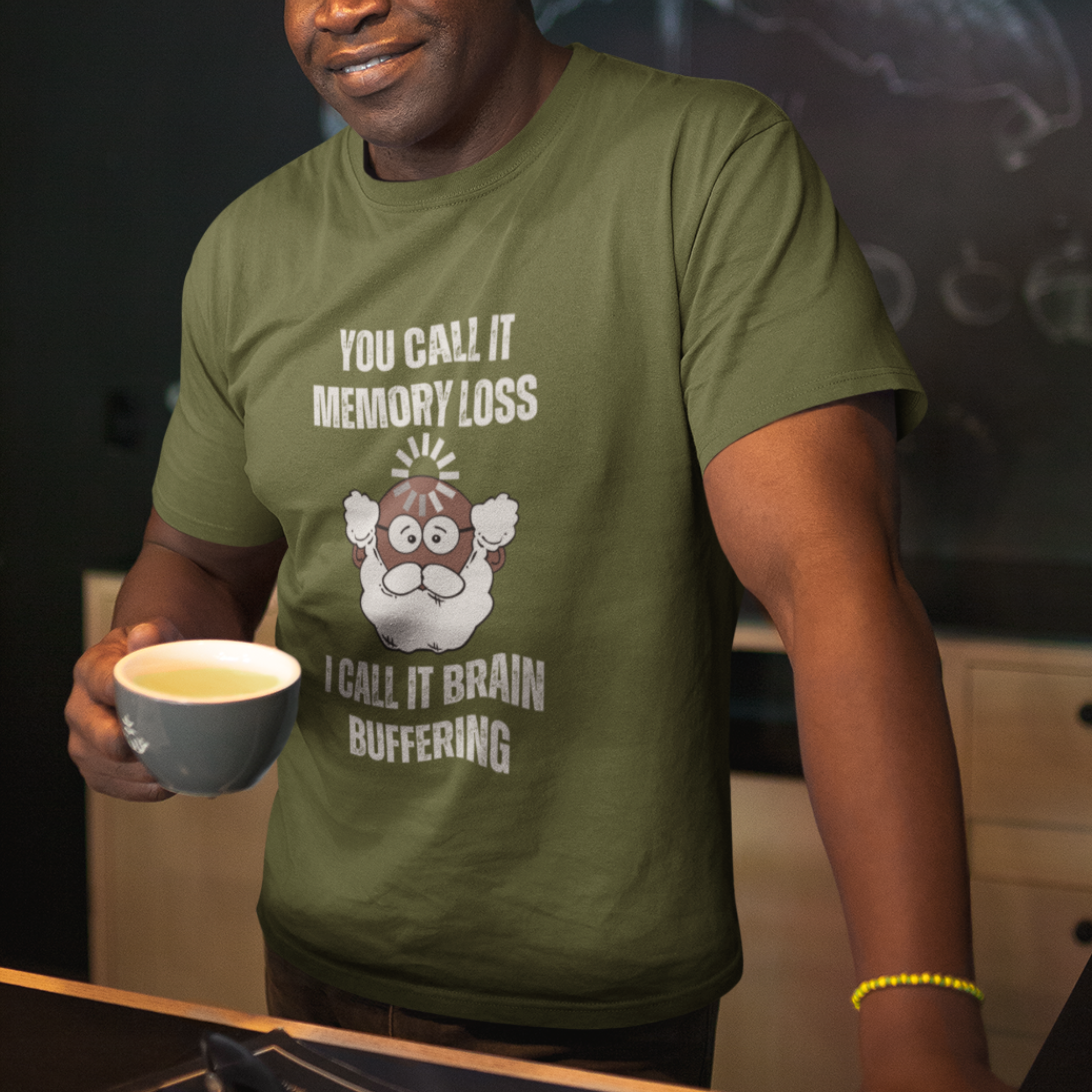 Military green t-shirt featuring the phrase 'Brain Buffering' with a loading icon graphic and a bald, bearded dark-toned senior.