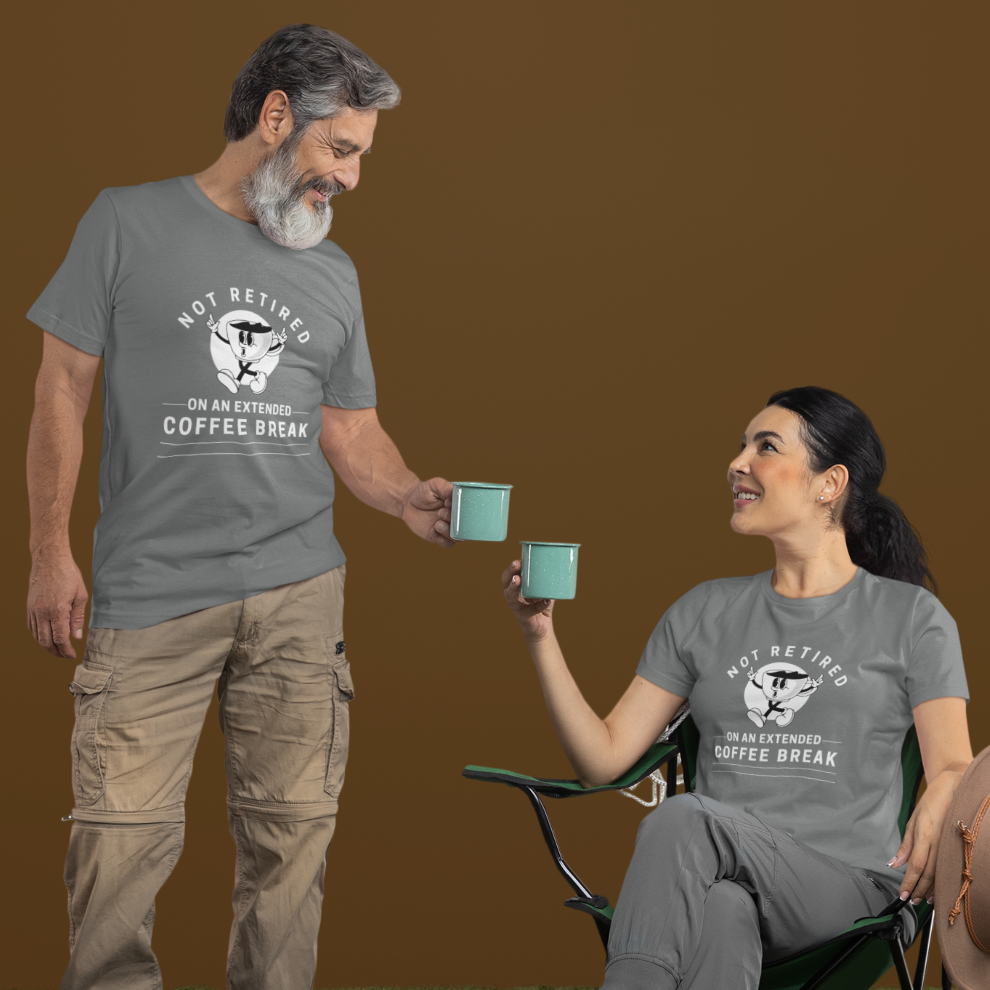 A couple in gray t-shirts featuring a whistling cartoon coffee cup that reads, Not Retired On An Extended Coffee Break. 