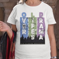 White t-shirt featuring pastel stripes and lettering with a forest scene in silhouette, stating Over Life's Drama This is Aging Gracefully