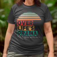 Black t-shirt that reads Over Life's Drama This is Aging Gracefully, featuring colorful block lettering and a rainbow striped sunset.