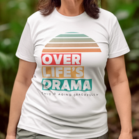White t-shirt that reads Over Life's Drama This is Aging Gracefully, featuring colorful block lettering and a rainbow striped sunset.