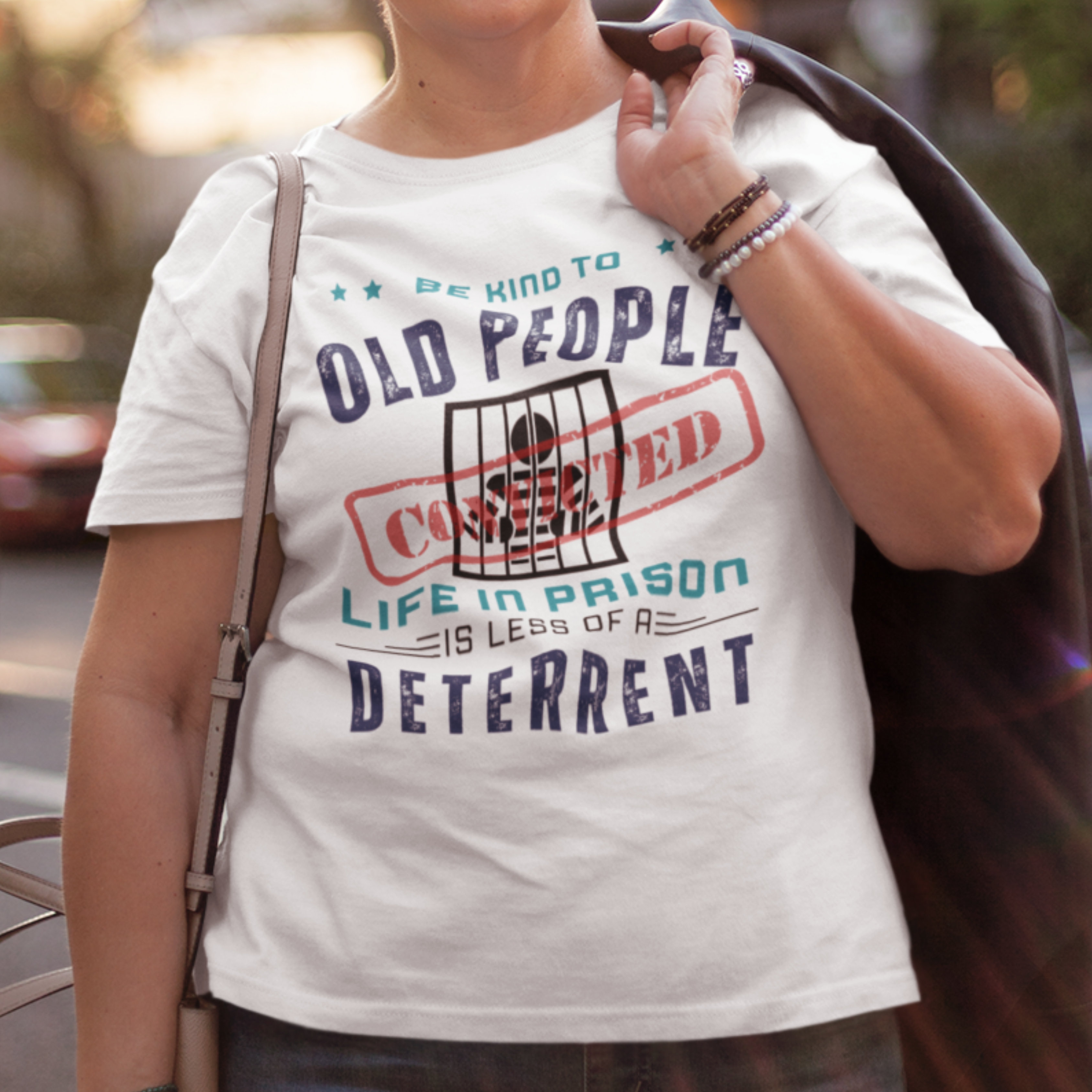 White t-shirt that reads Be Kind to Old People Life in Prison is Less of a Deterrent and features a prisoner behind bars pictogram.