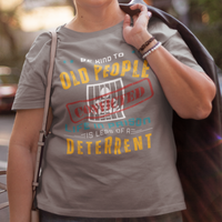 Gray t-shirt that reads Be Kind to Old People Life in Prison is Less of a Deterrent and features a prisoner behind bars pictogram.