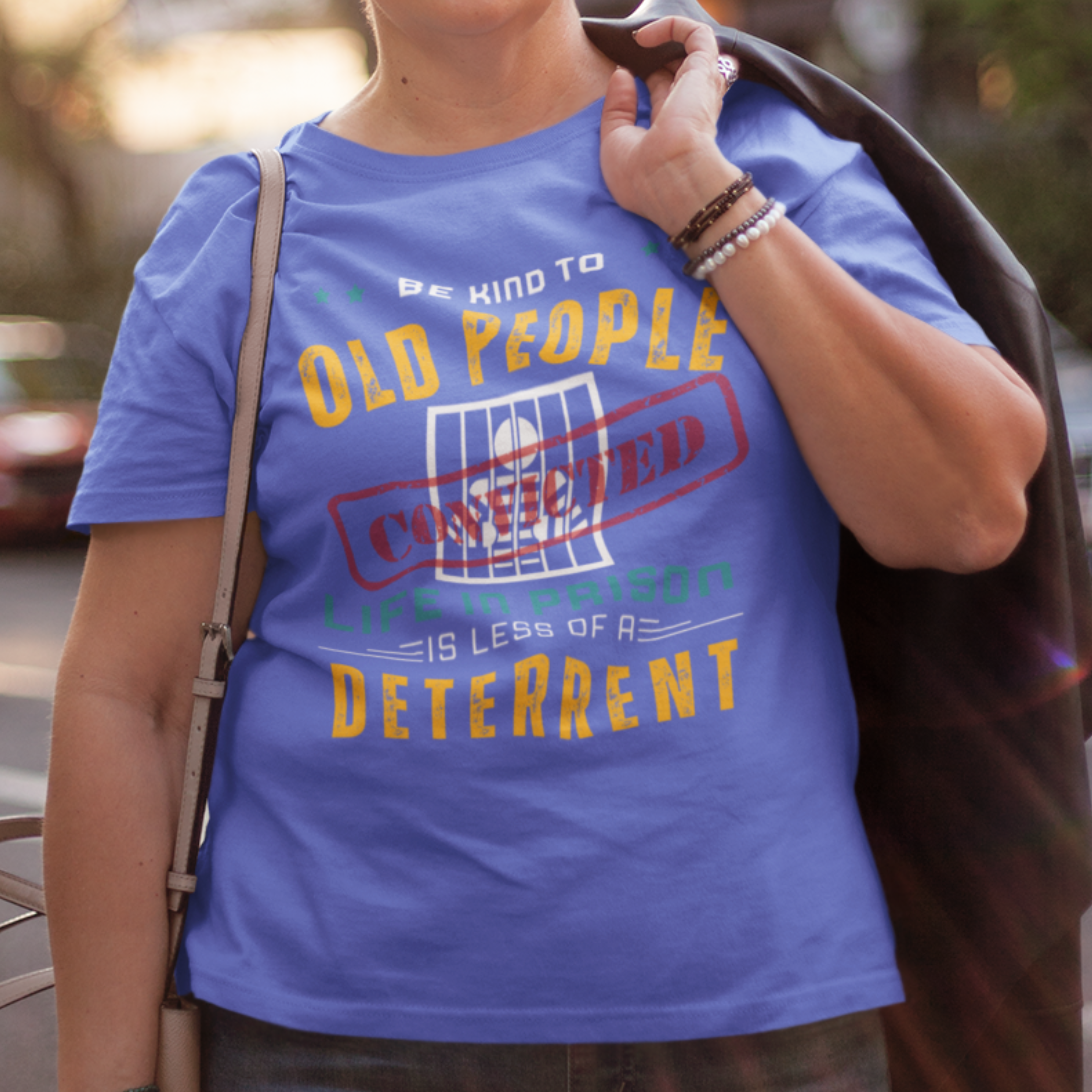 Royal blue t-shirt that reads Be Kind to Old People Life in Prison is Less of a Deterrent and features a prisoner behind bars pictogram.
