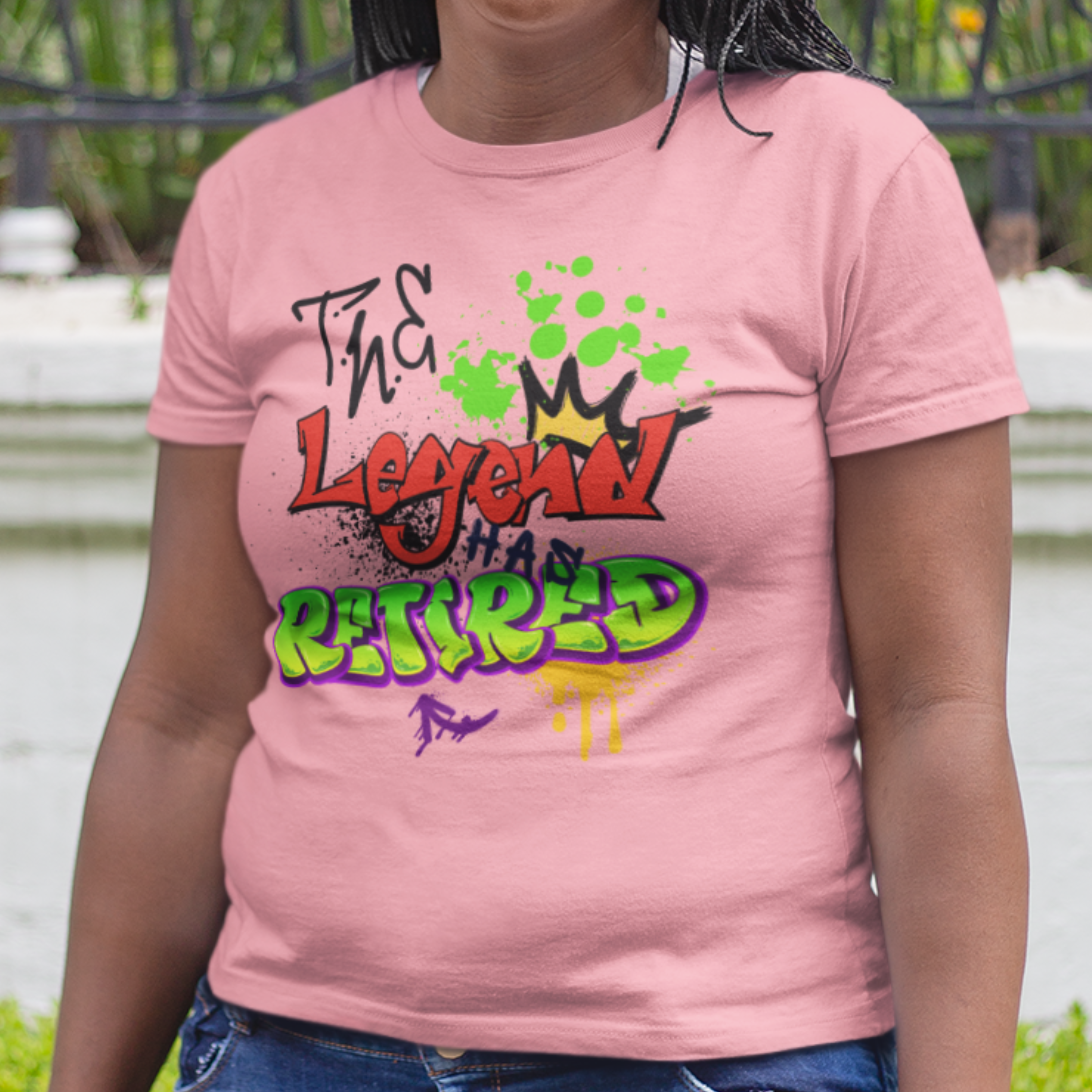 Light pink t-shirt featuring bold graffiti style fonts states "The Legend Has Retired"
