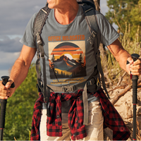Heather gray tee on a male hiker featuring a mountain peak at sunset in warm colors that reads Office Relocated No Forwarding Address Provided