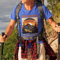 Royal blue tee on a male hiker featuring a mountain peak at sunset in warm colors that reads Office Relocated No Forwarding Address Provided