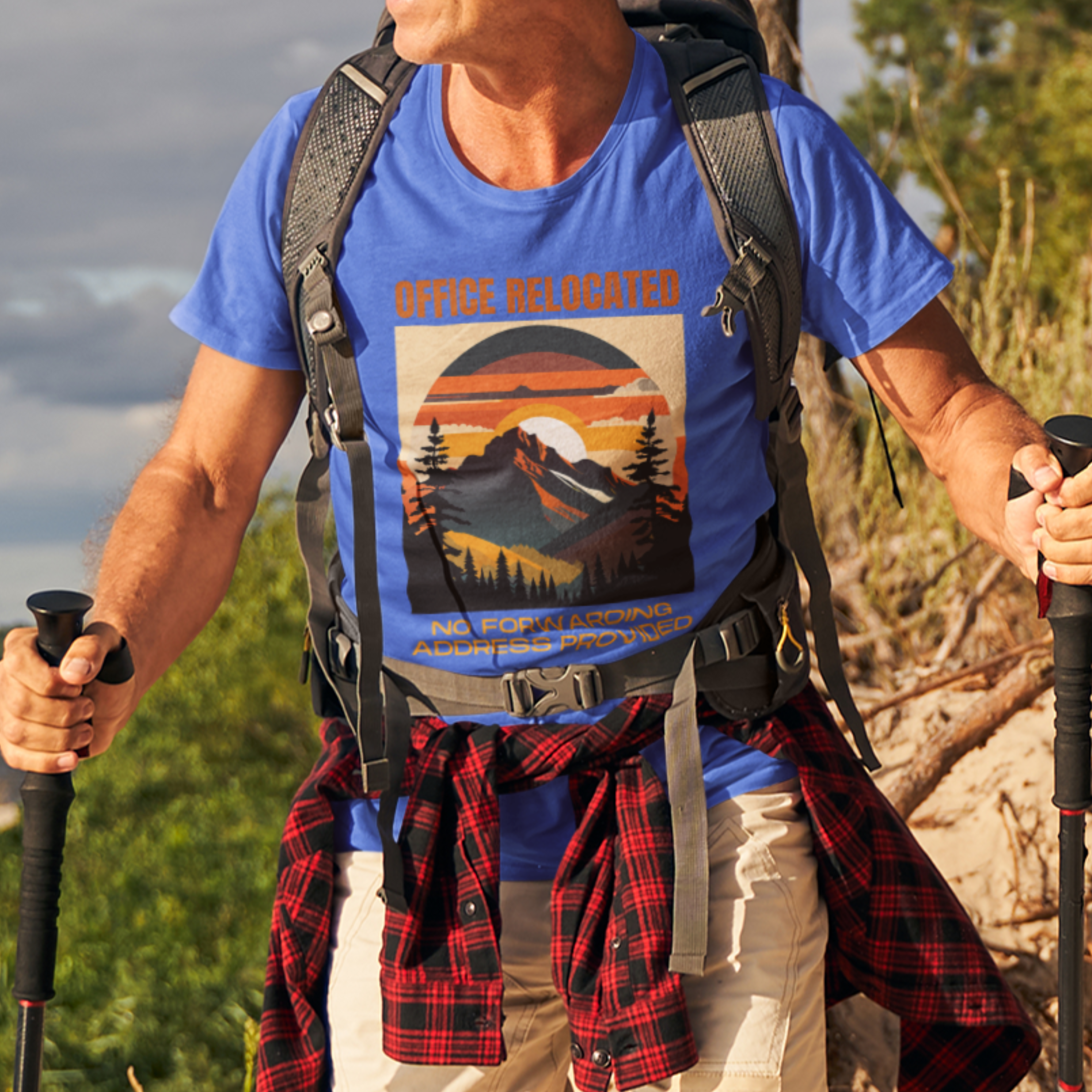 Royal blue tee on a male hiker featuring a mountain peak at sunset in warm colors that reads Office Relocated No Forwarding Address Provided