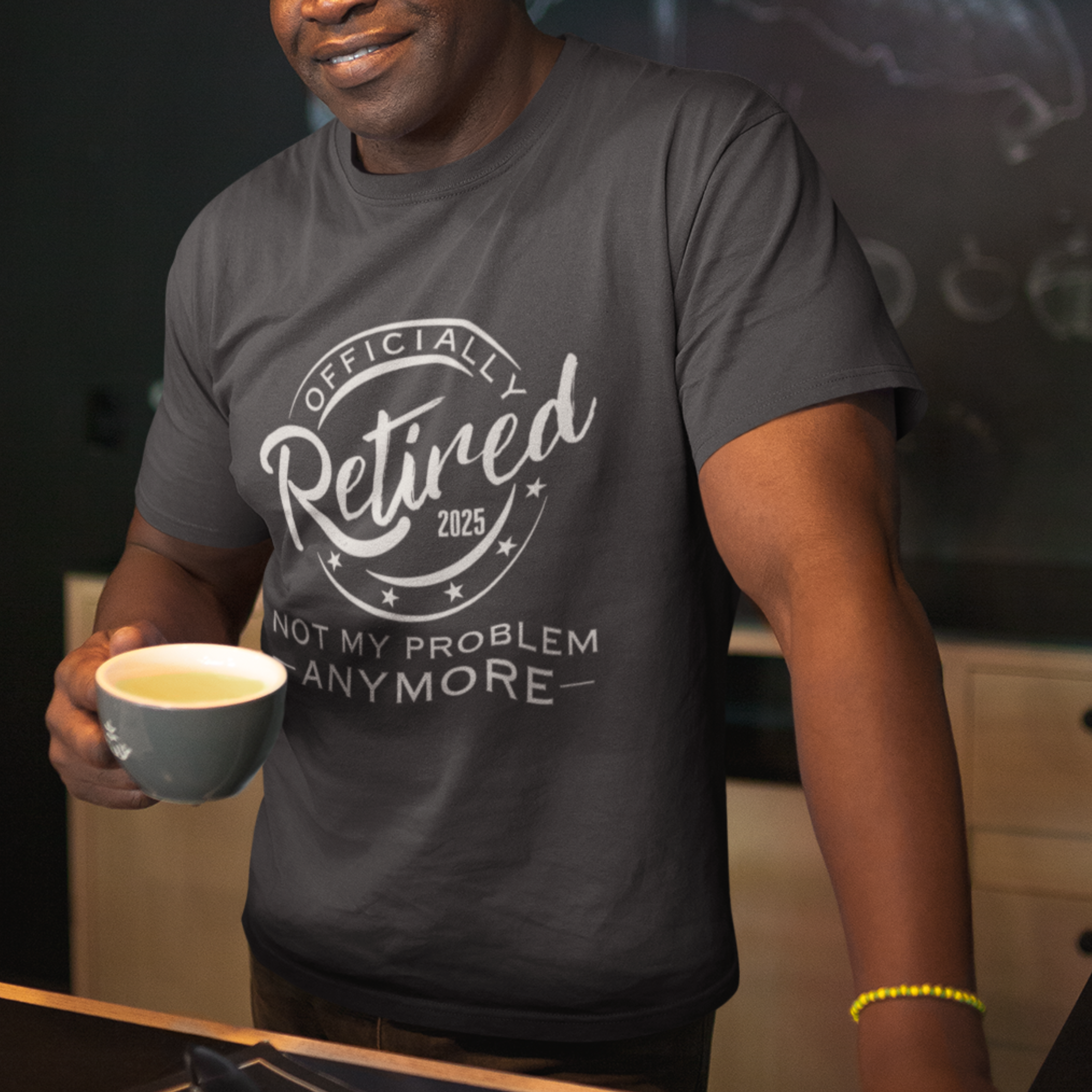 Black tee featuring a replica of an official stamp embossing that reads "Officially Retired 2025 Not My Problem Anymore"
