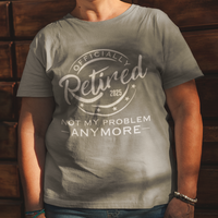 Heather gray tee featuring a replica of an official stamp embossing that reads "Officially Retired 2025 Not My Problem Anymore"