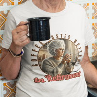 White tee featuring a senior woman at her kitchen table enjoying a hot cup of coffee.