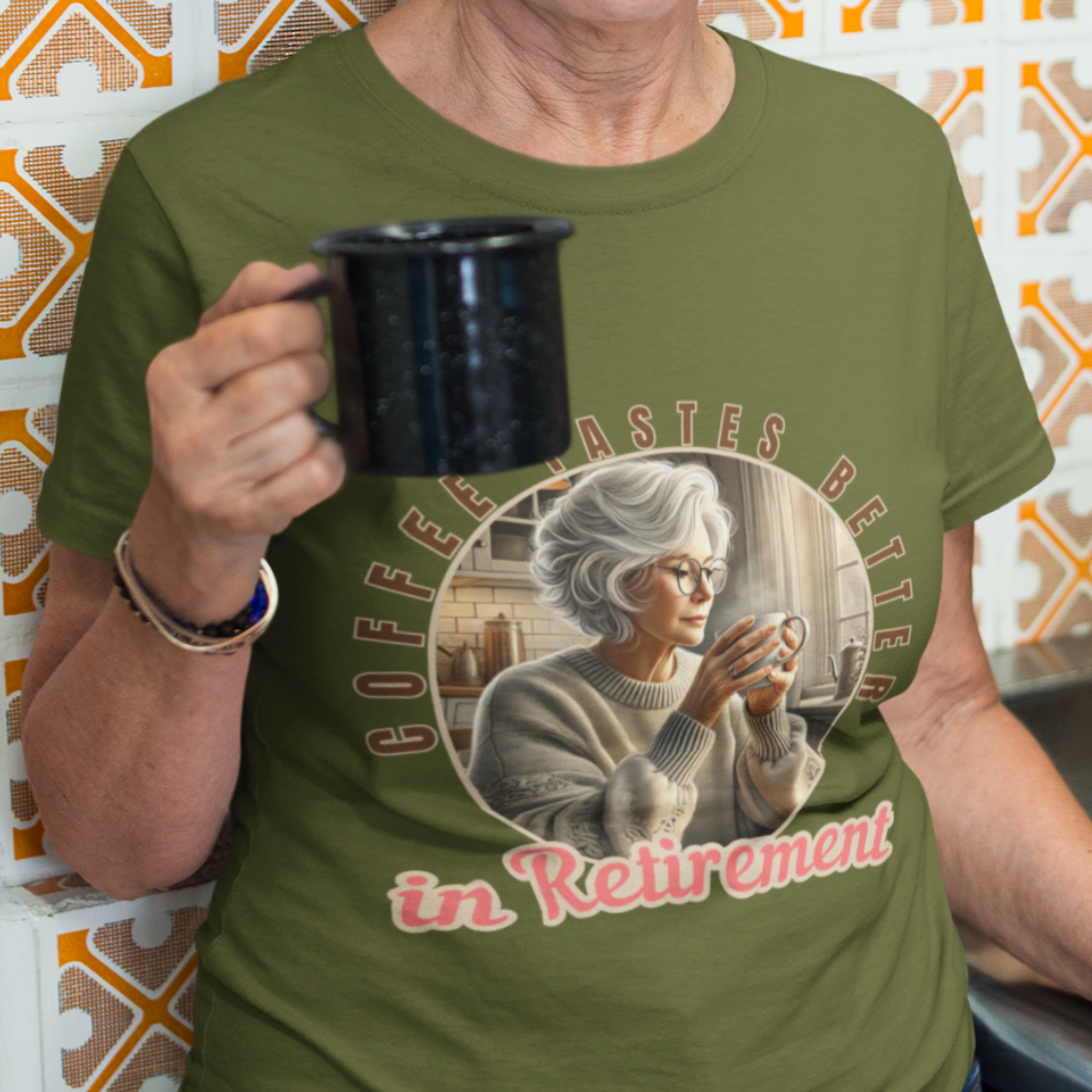 Military green tee featuring a senior woman at her kitchen table enjoying a hot cup of coffee.